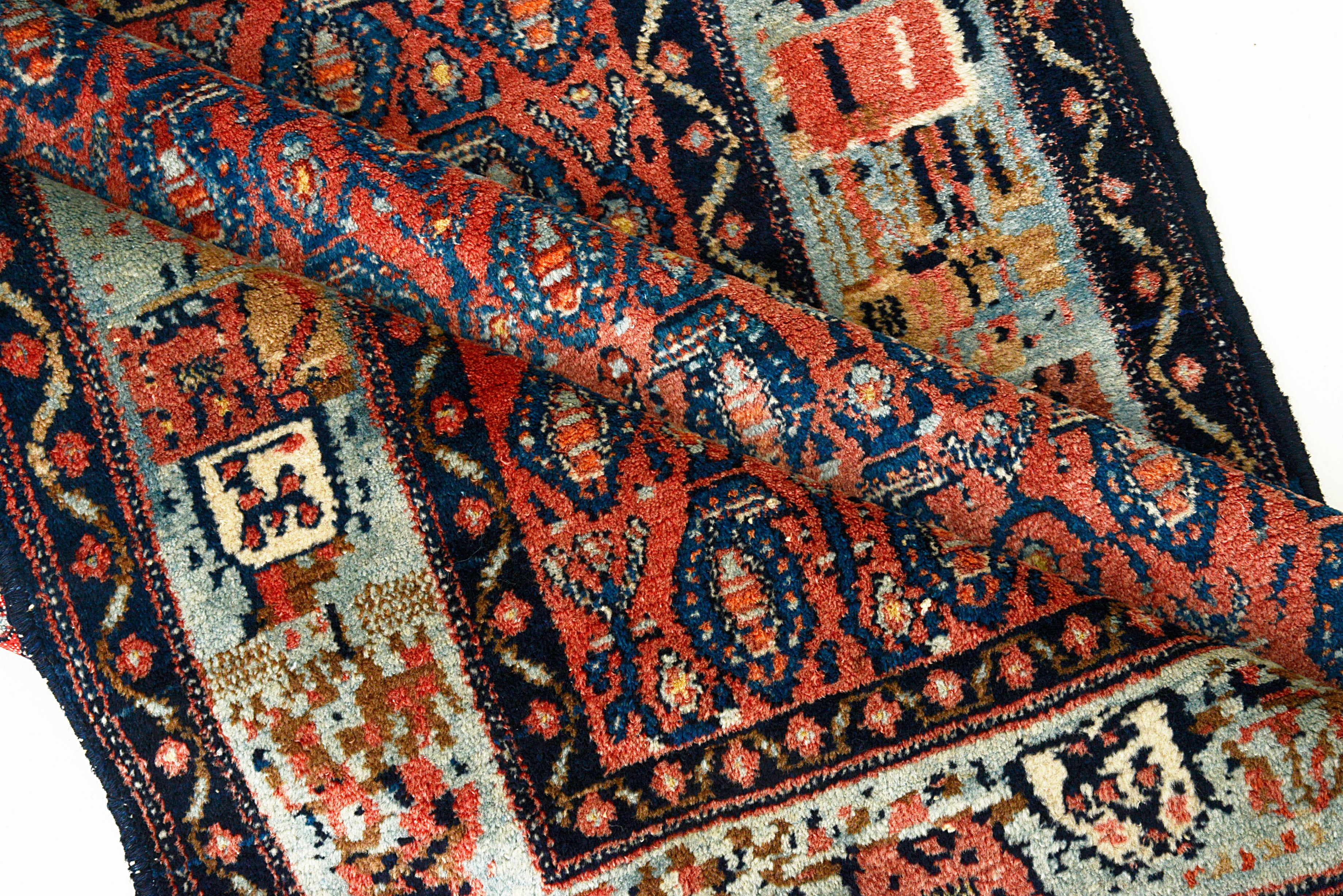 Close-up of a patterned Antique Persian Senneh rug with intricate designs.