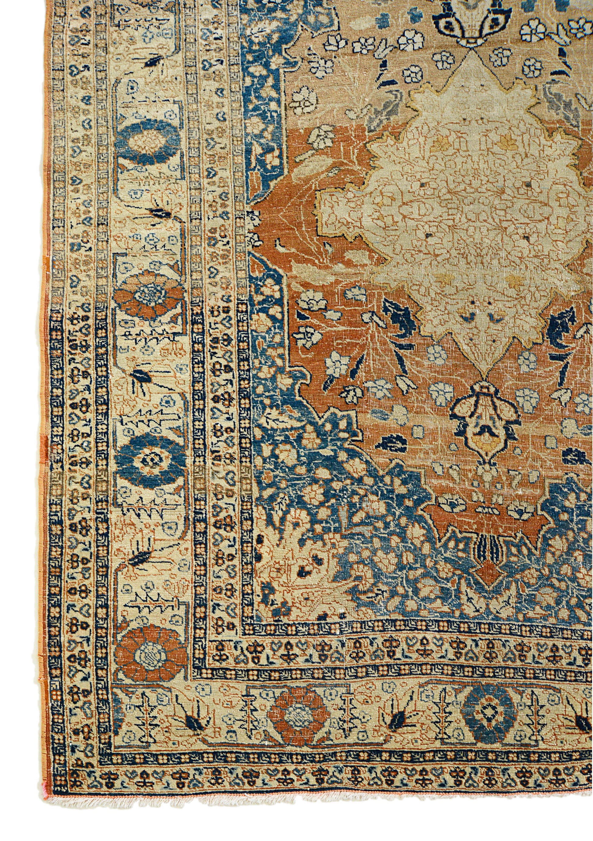 Corner view of an antique Persian Tabriz rug showing border and field details