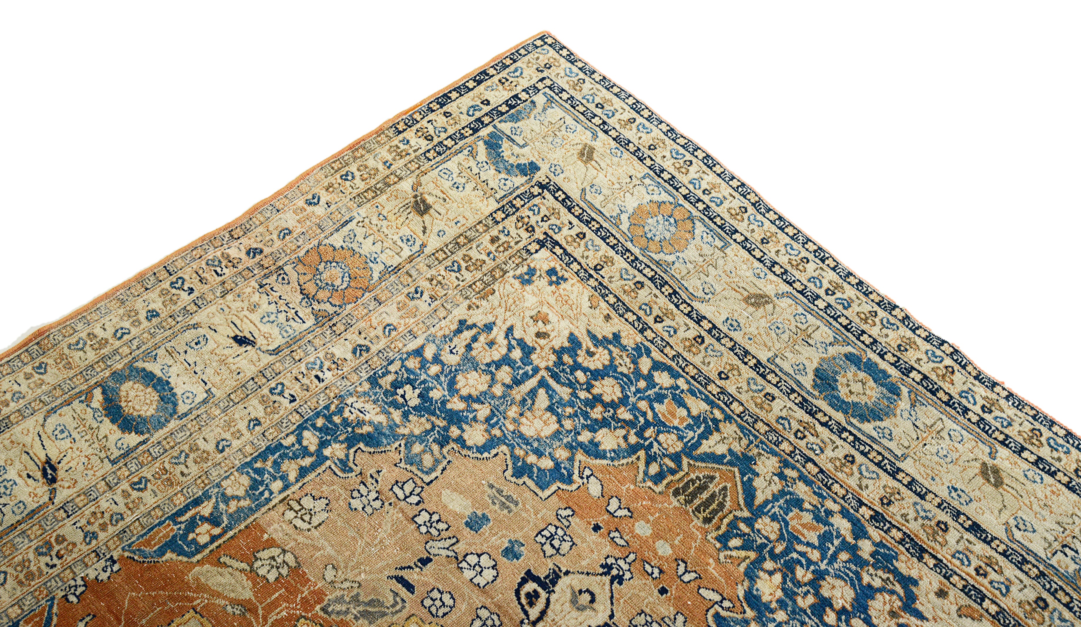 Close-up of a Antique Tabriz rug with intricate designs on a white background