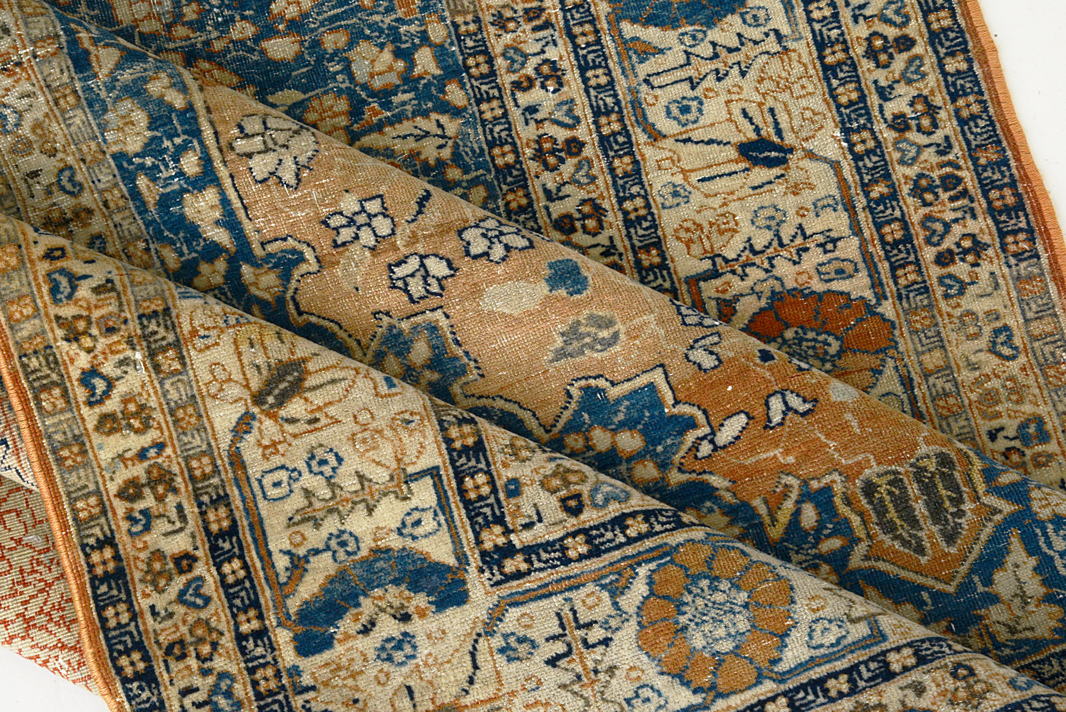 Close-up of an intricately designed handmade Tabriz rug with blue, brown, and beige colors.
