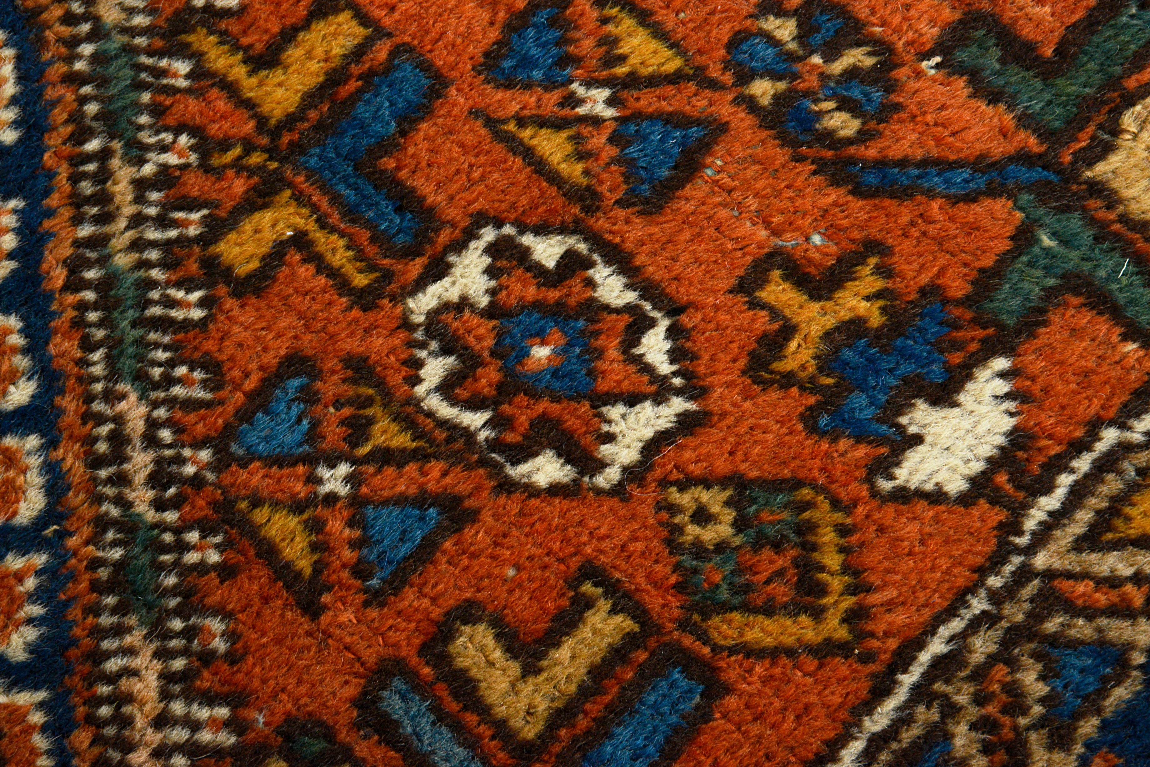 Close-up of a patterned rug with vibrant colors and intricate design.