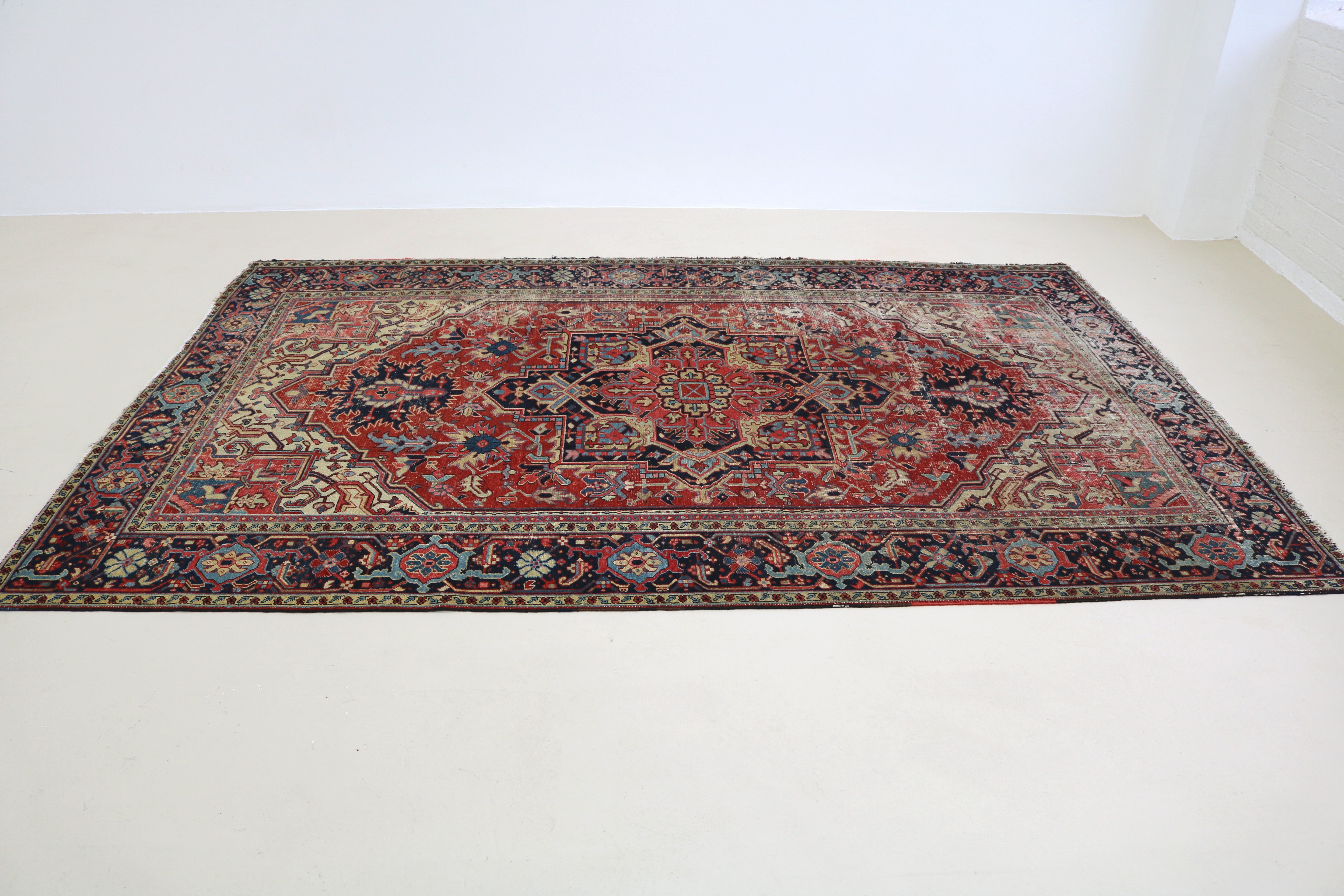 Perspective view of fine antique Persian Heriz carpet laid on floor