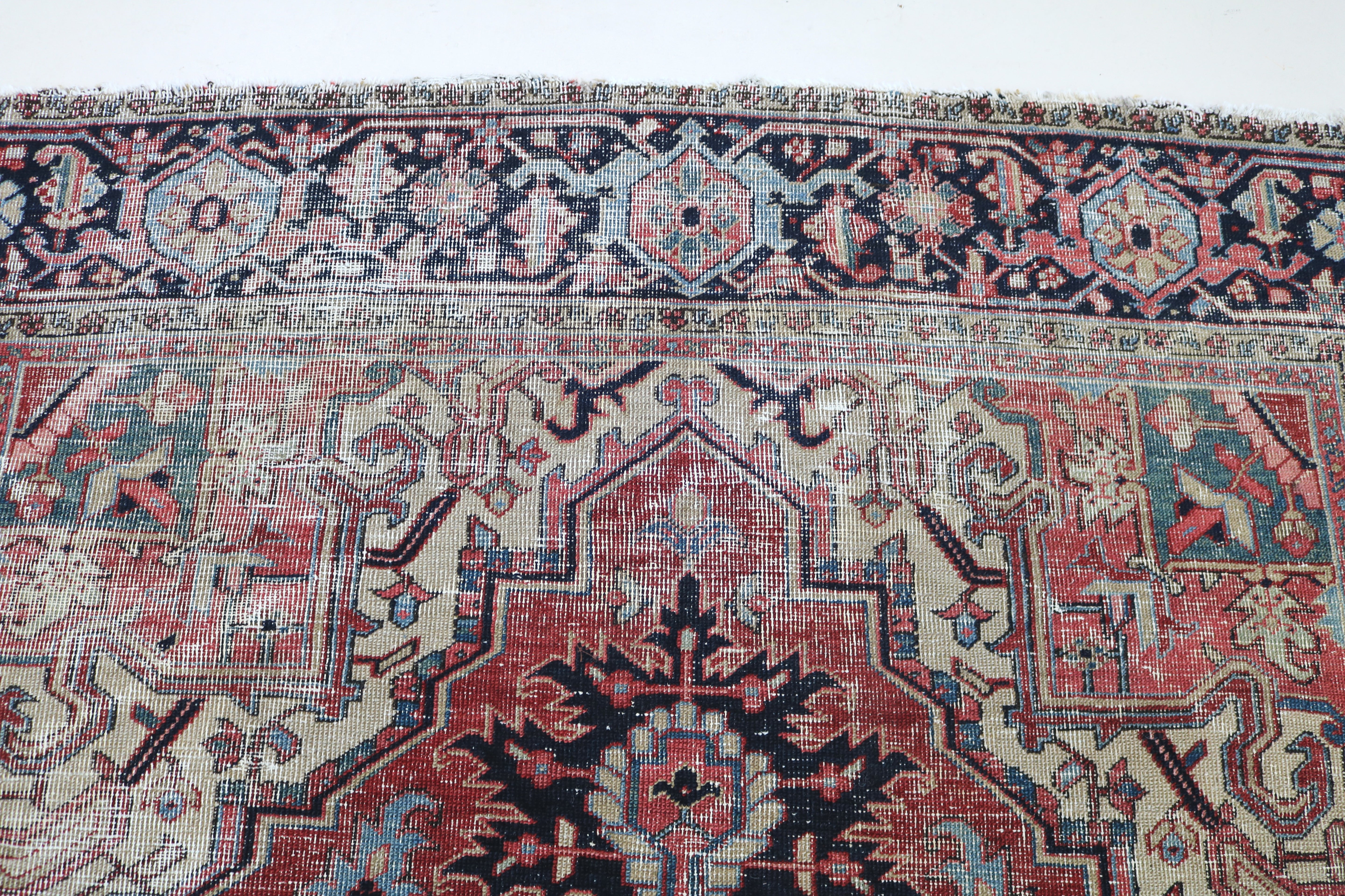 Close-up of hand-knotted wool texture on fine antique Persian Heriz carpet