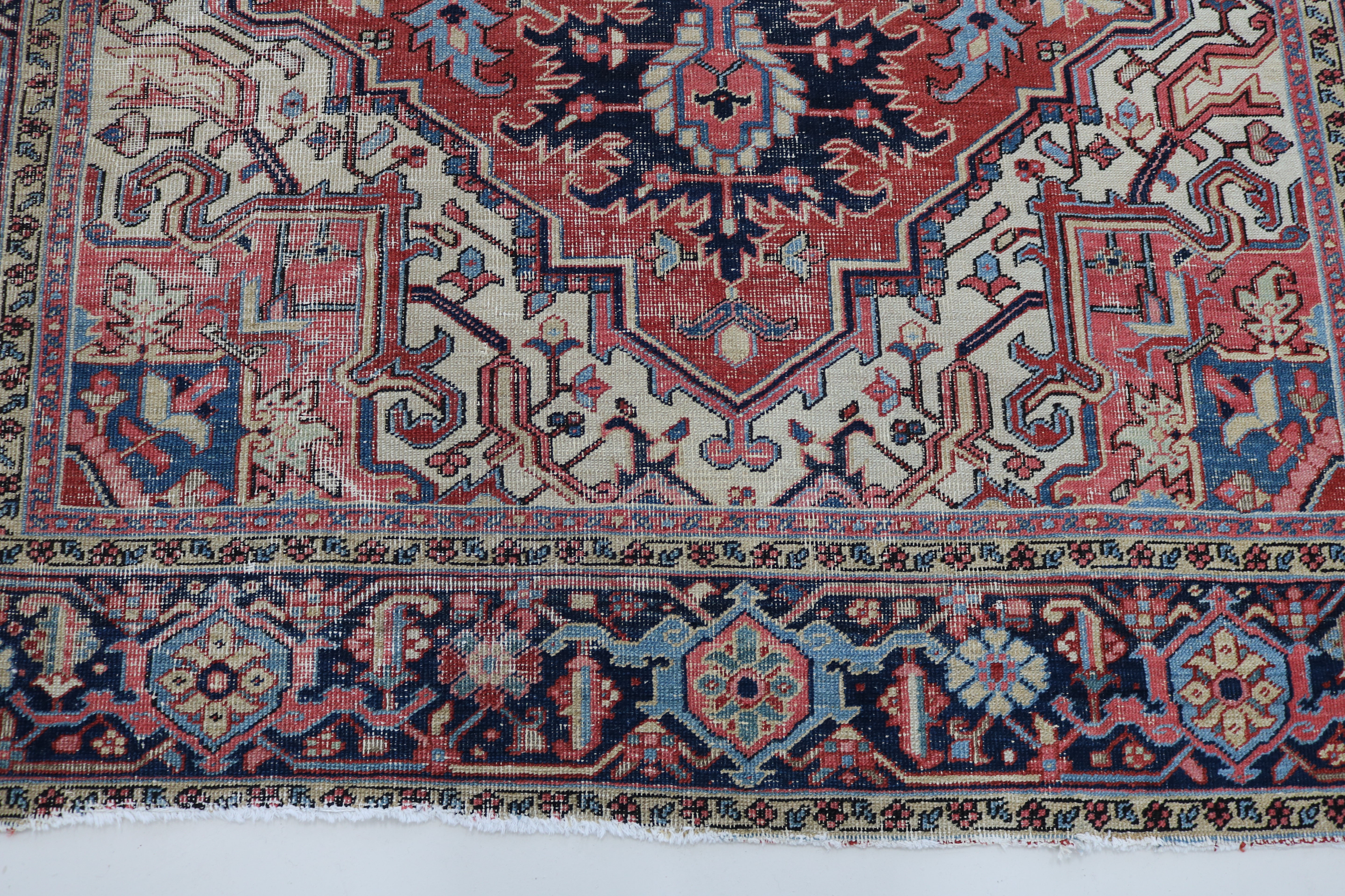 Close-up of hand-knotted wool texture on fine antique Persian Heriz carpet