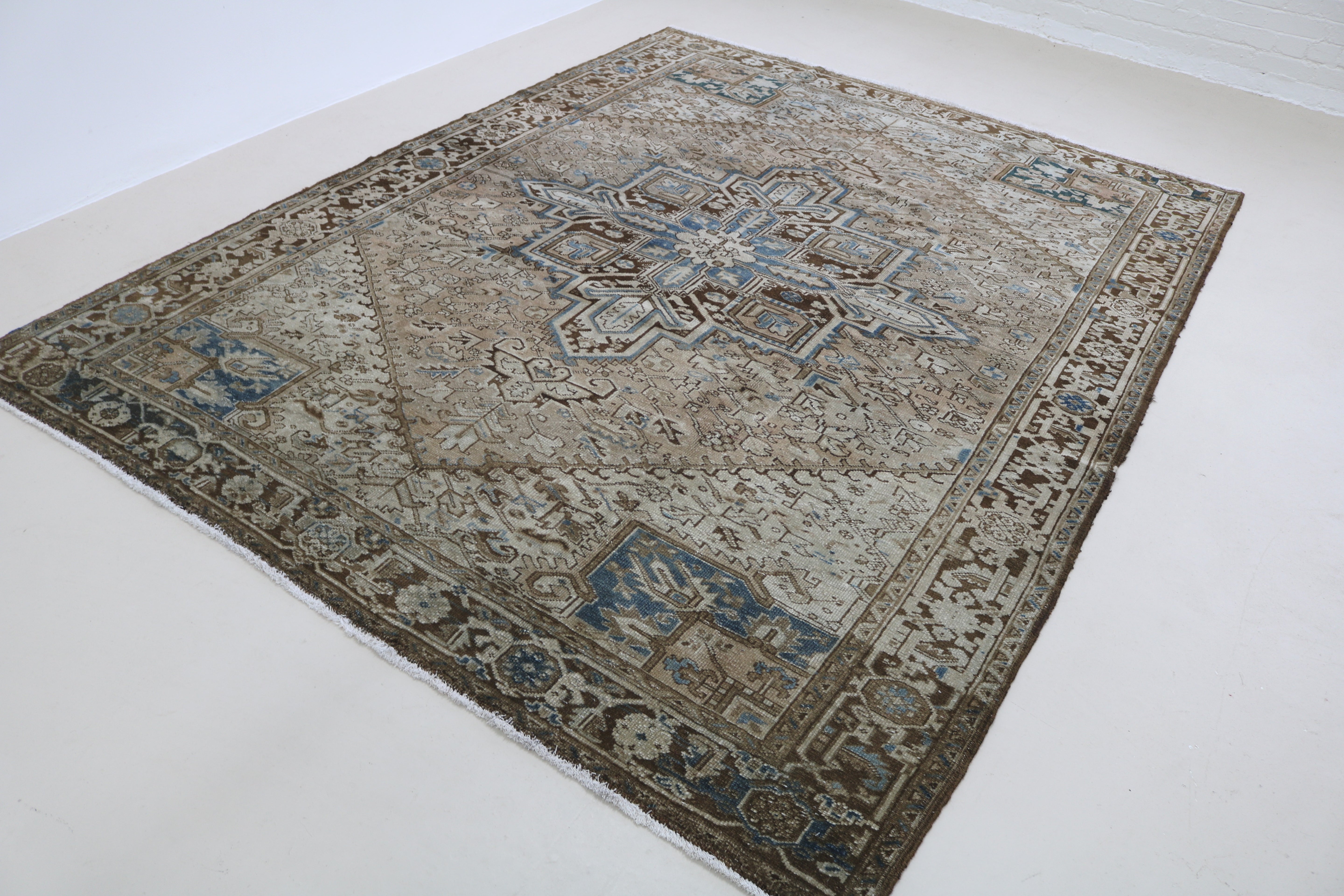 Angled view of antique Persian Heriz carpet highlighting overall pattern and composition