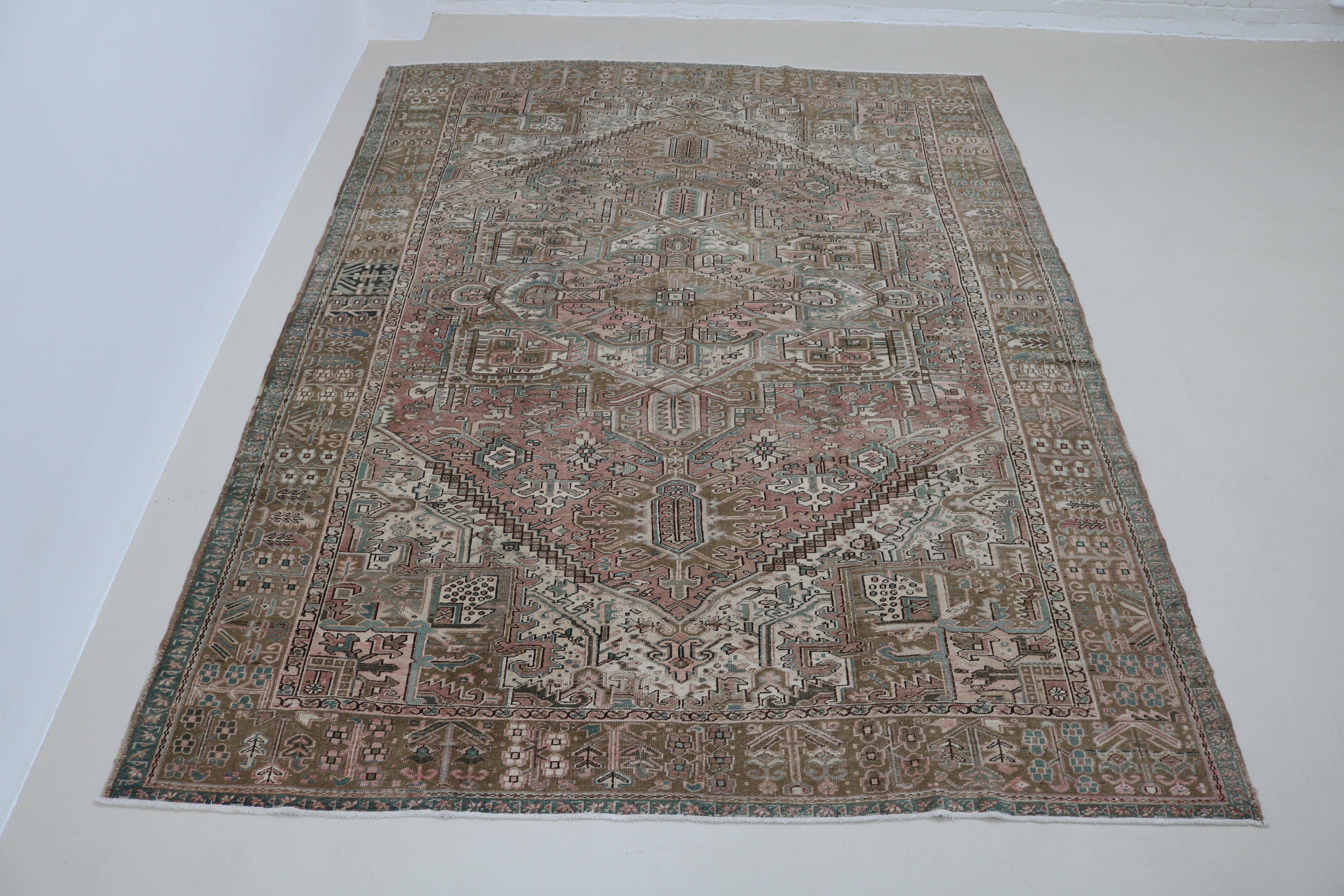 Full view of antique Persian Heriz carpet with strong geometric field and architectural borders