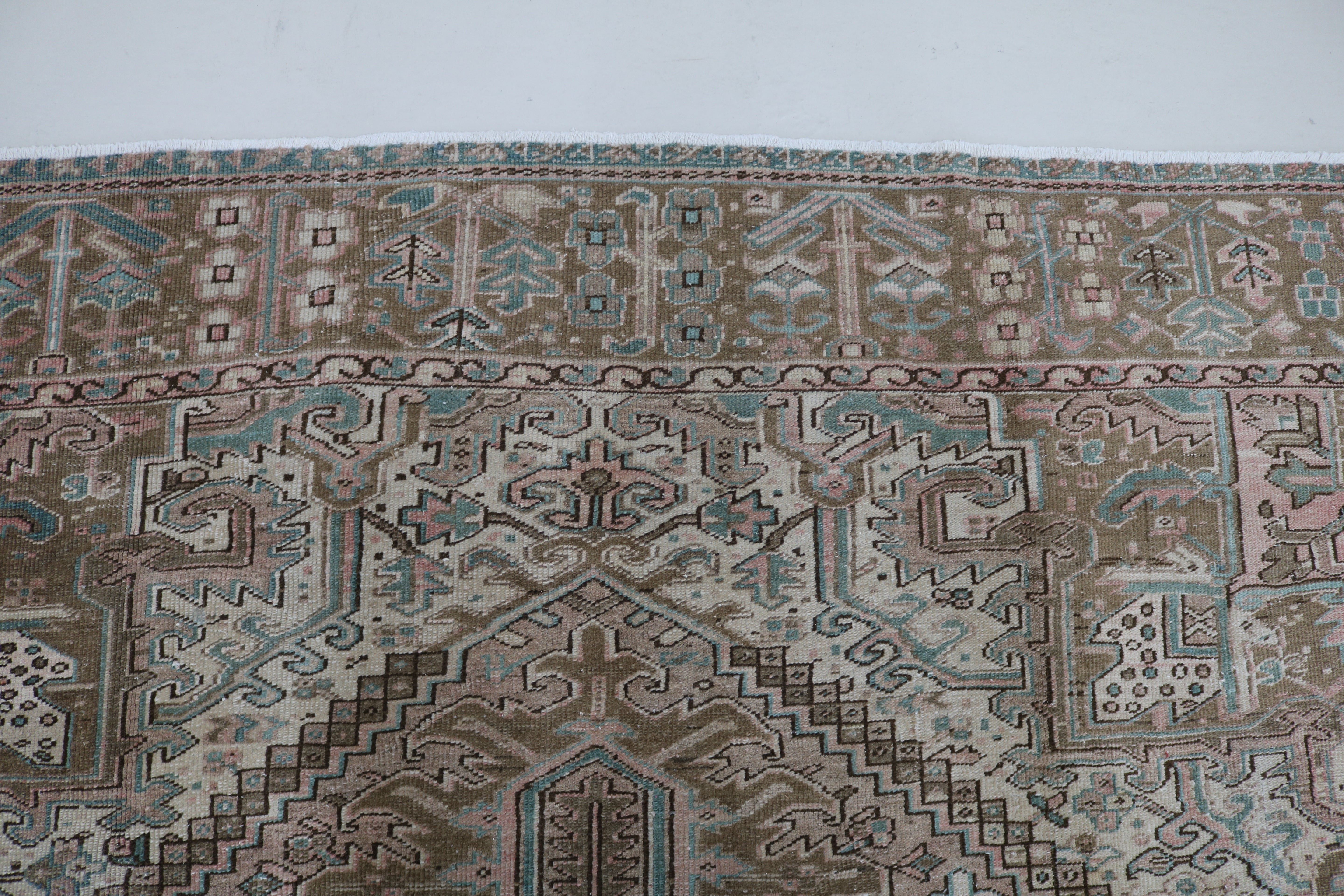 Close-up of hand-knotted wool texture on antique Persian Heriz carpet