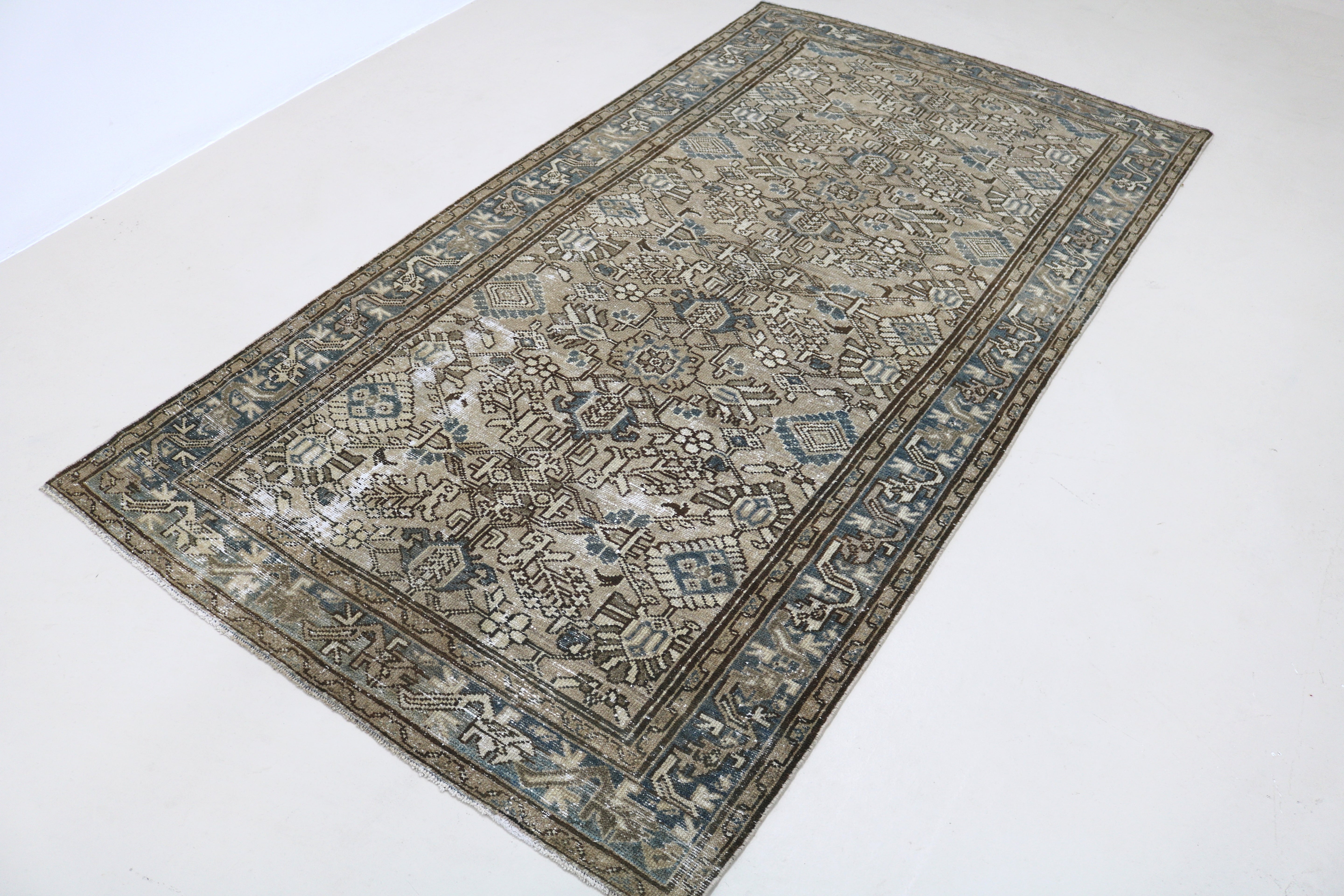 Angled view of antique Persian Karaja rug highlighting overall pattern and composition