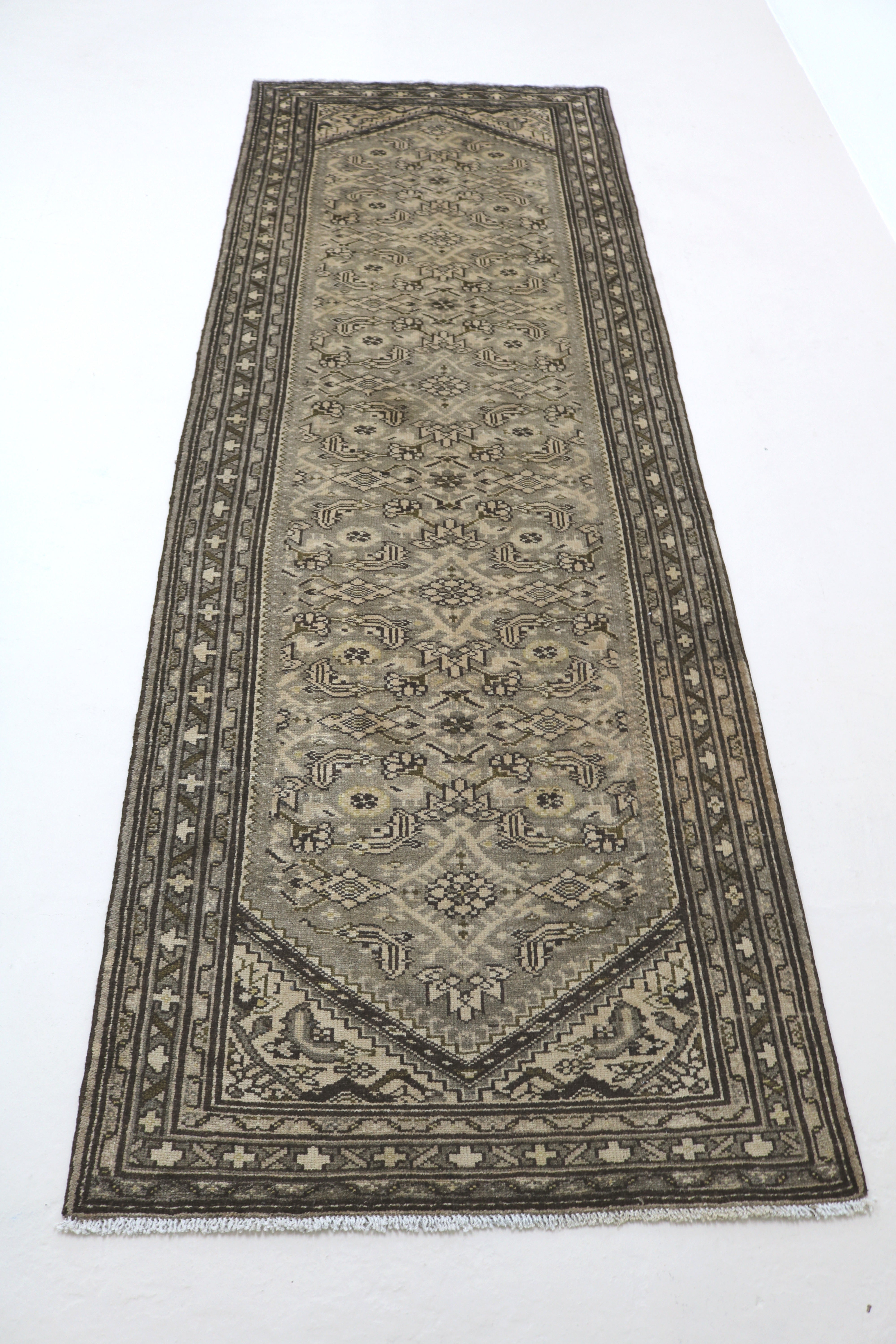 Perspective view of antique Persian Malayer runner laid on floor