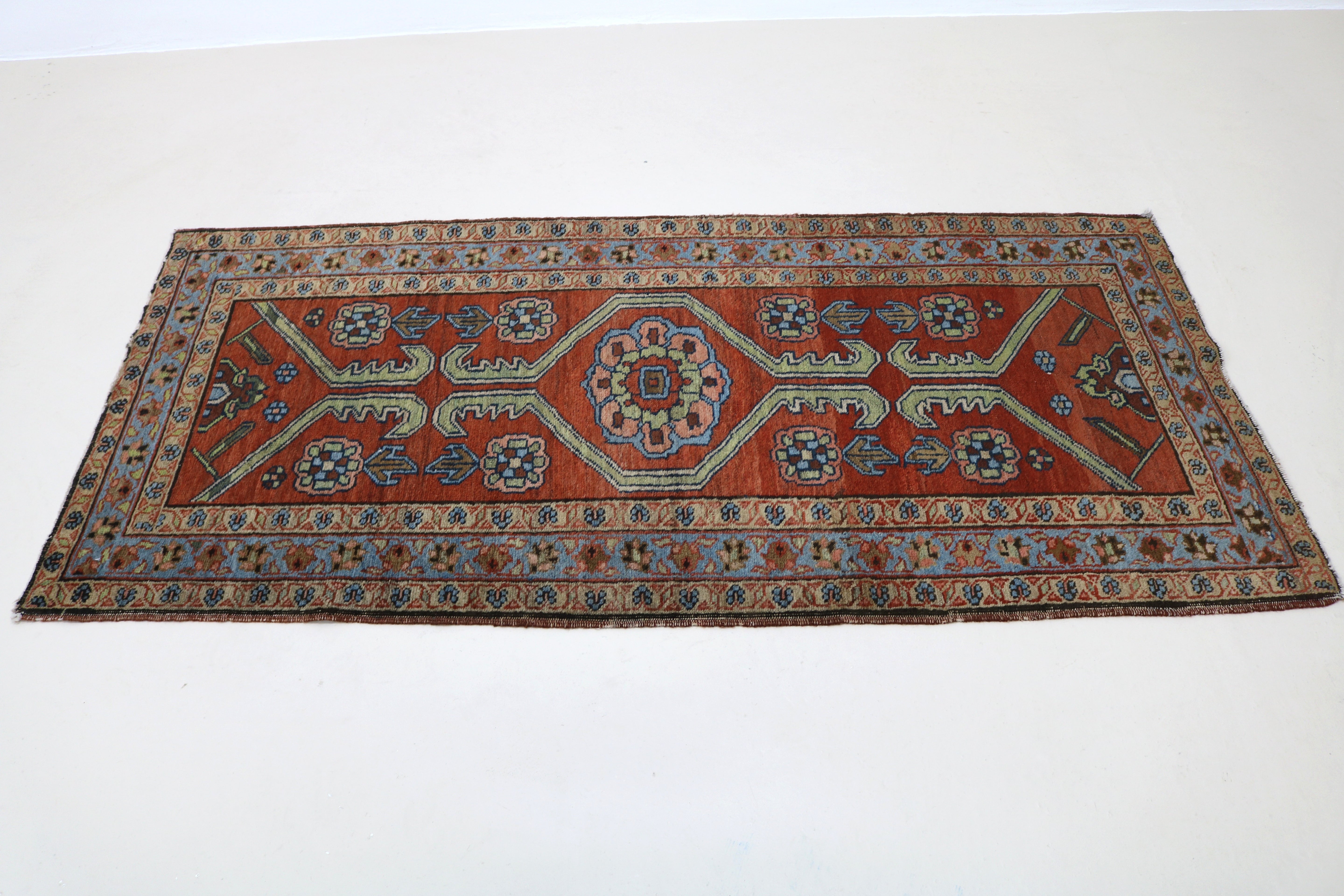 Perspective view of antique Persian Heriz rug laid on floor