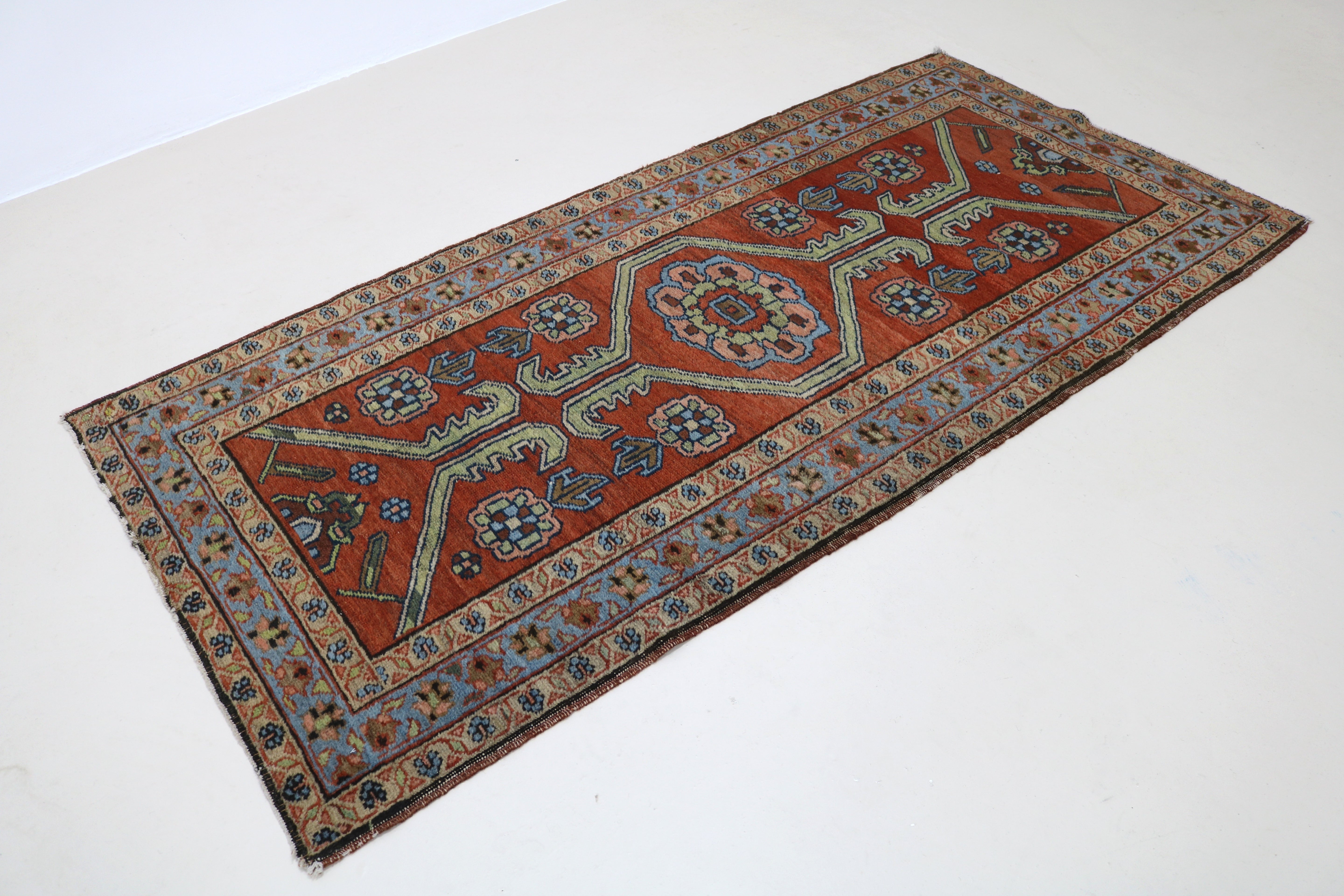 Angled view of antique Persian Heriz rug highlighting overall pattern and proportions