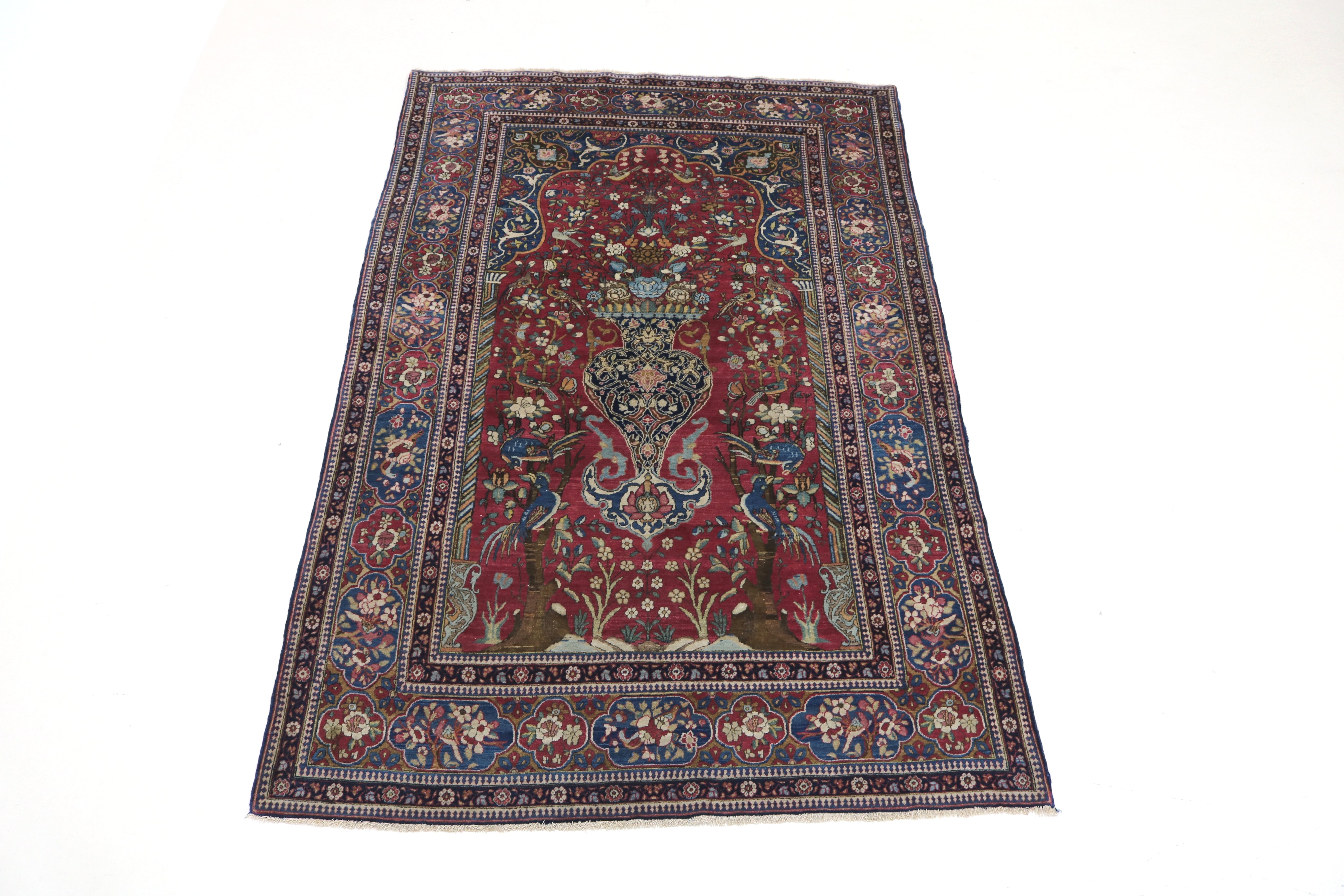 Full view of antique Isfahan rug with intricate floral field and balanced borders