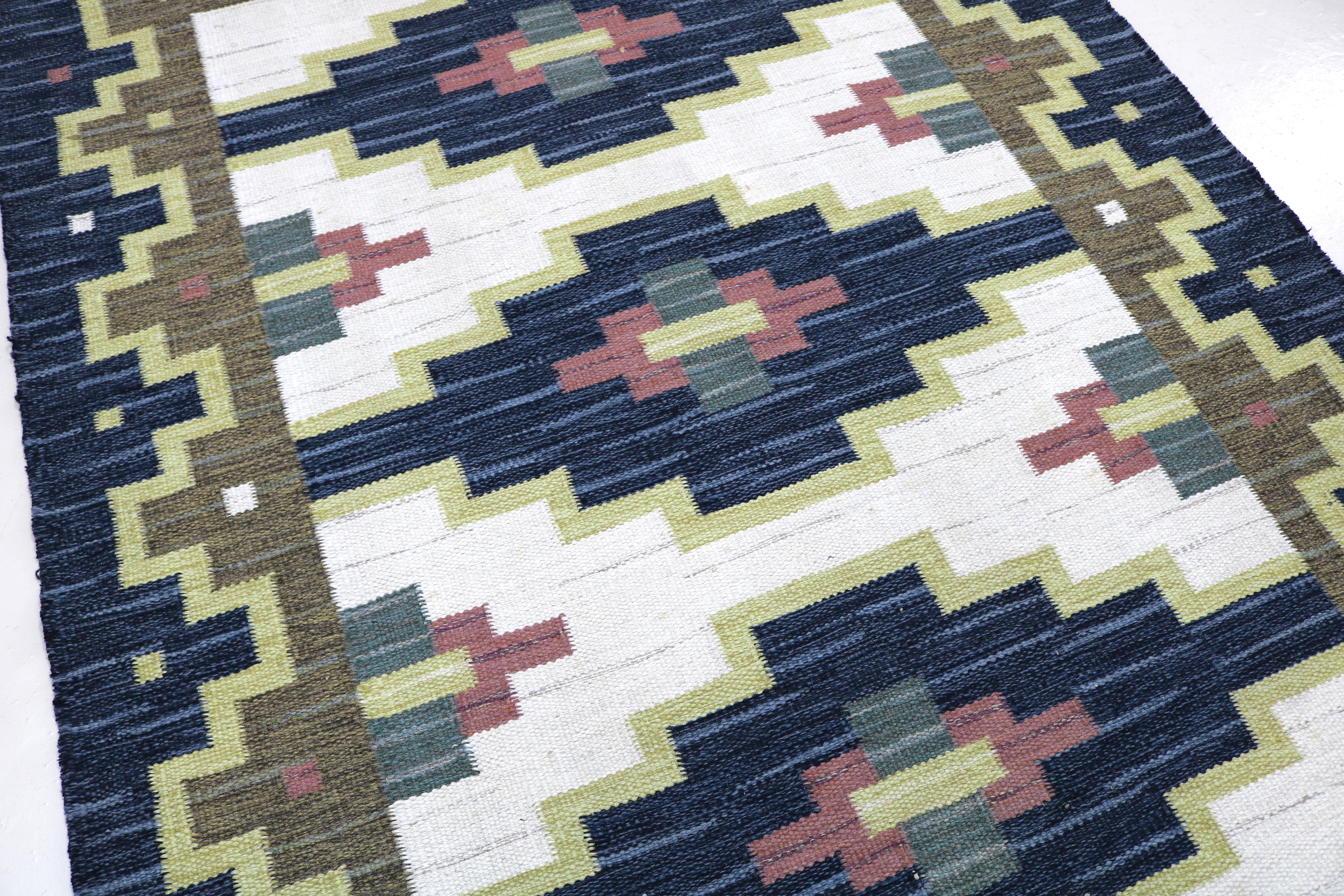 Detailed view of the handwoven geometric border on a vintage Swedish flatweave rug.