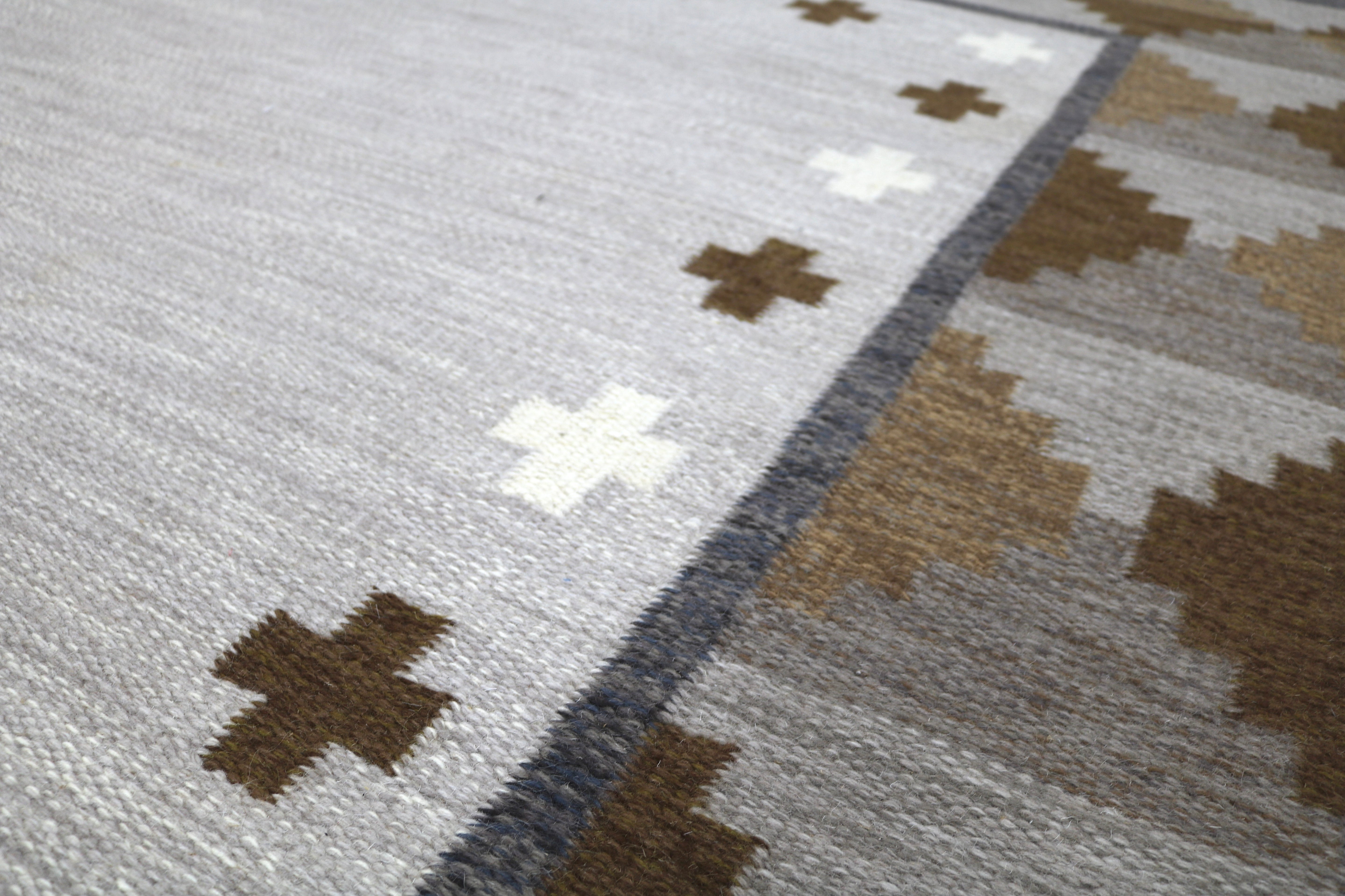 Corner detail of a mid-century Swedish kilim with geometric woven motifs.