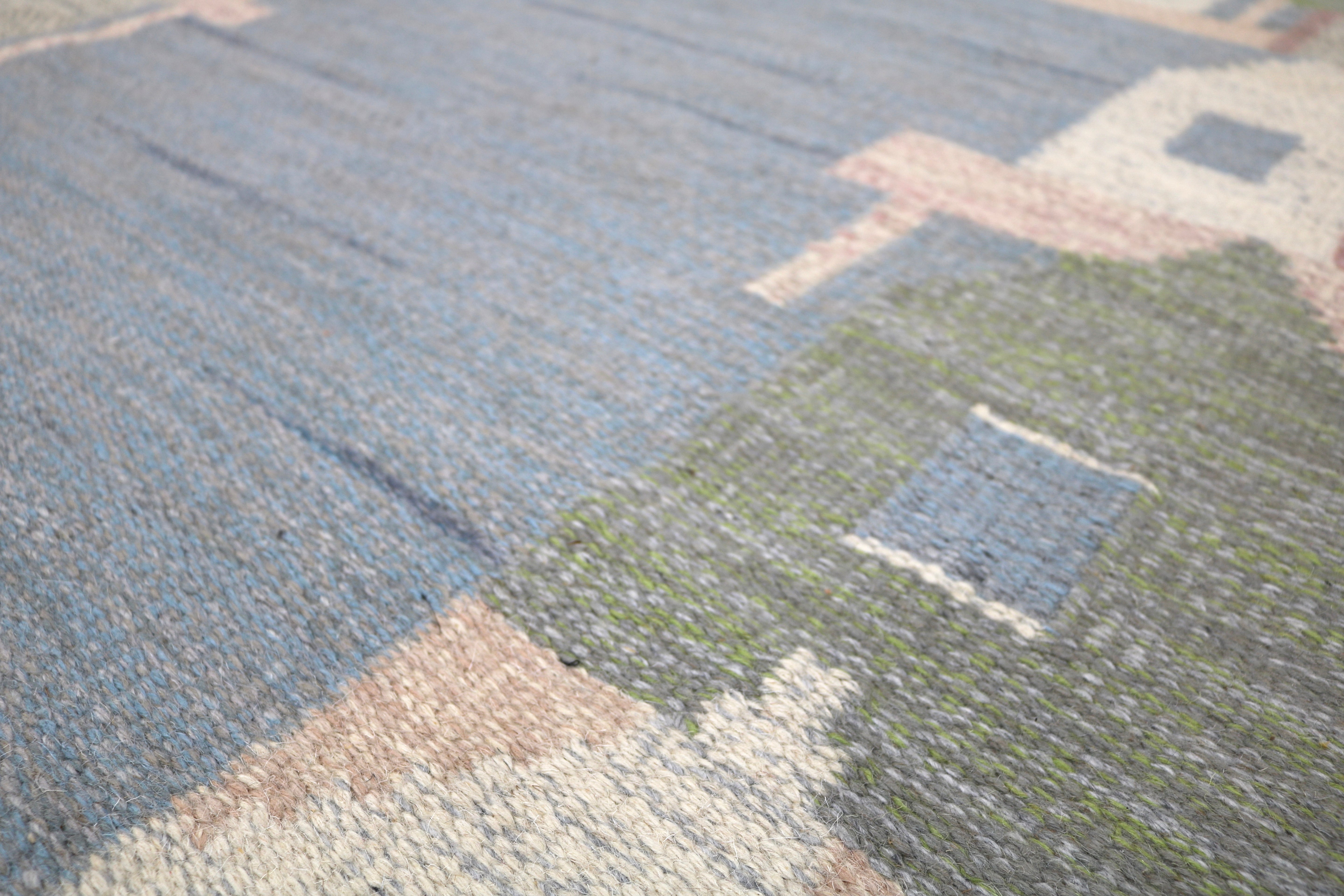 Detailed woven section of a Scandinavian village scene on a vintage Swedish rug.