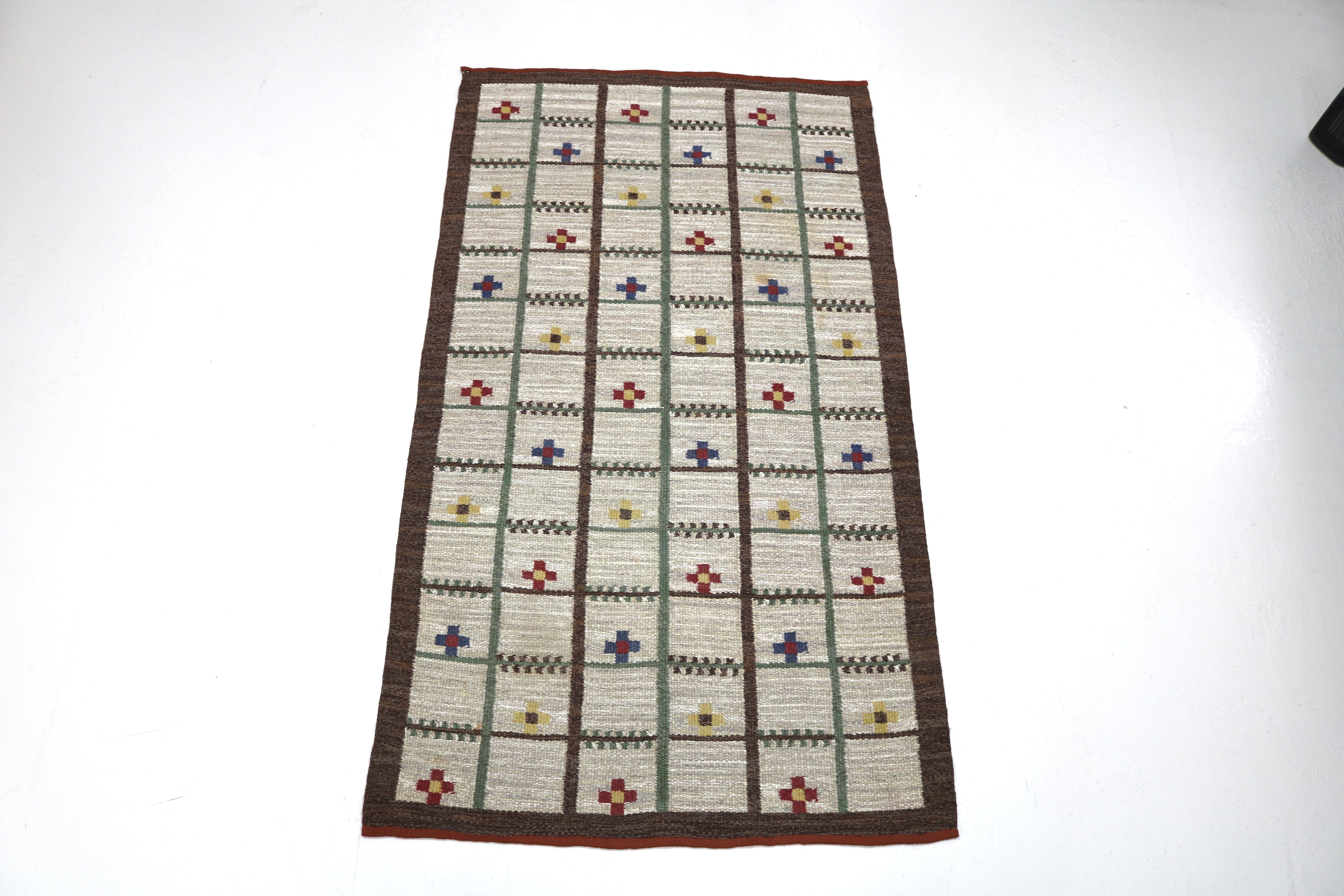 Handwoven Scandinavian kilim rug featuring an elegant geometric grid design.