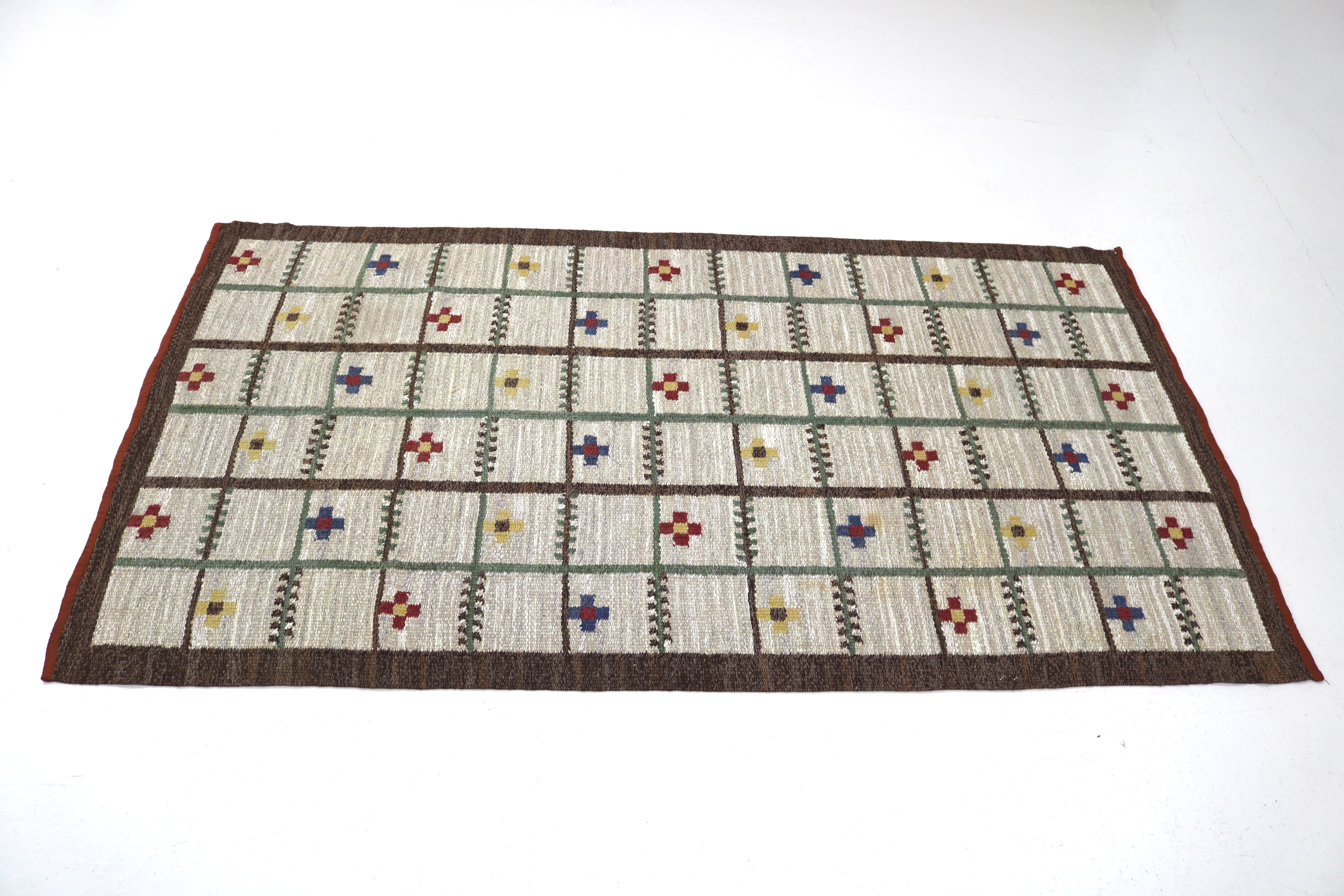 Close-up of colourful woven geometric motifs on a vintage Swedish wool rug.