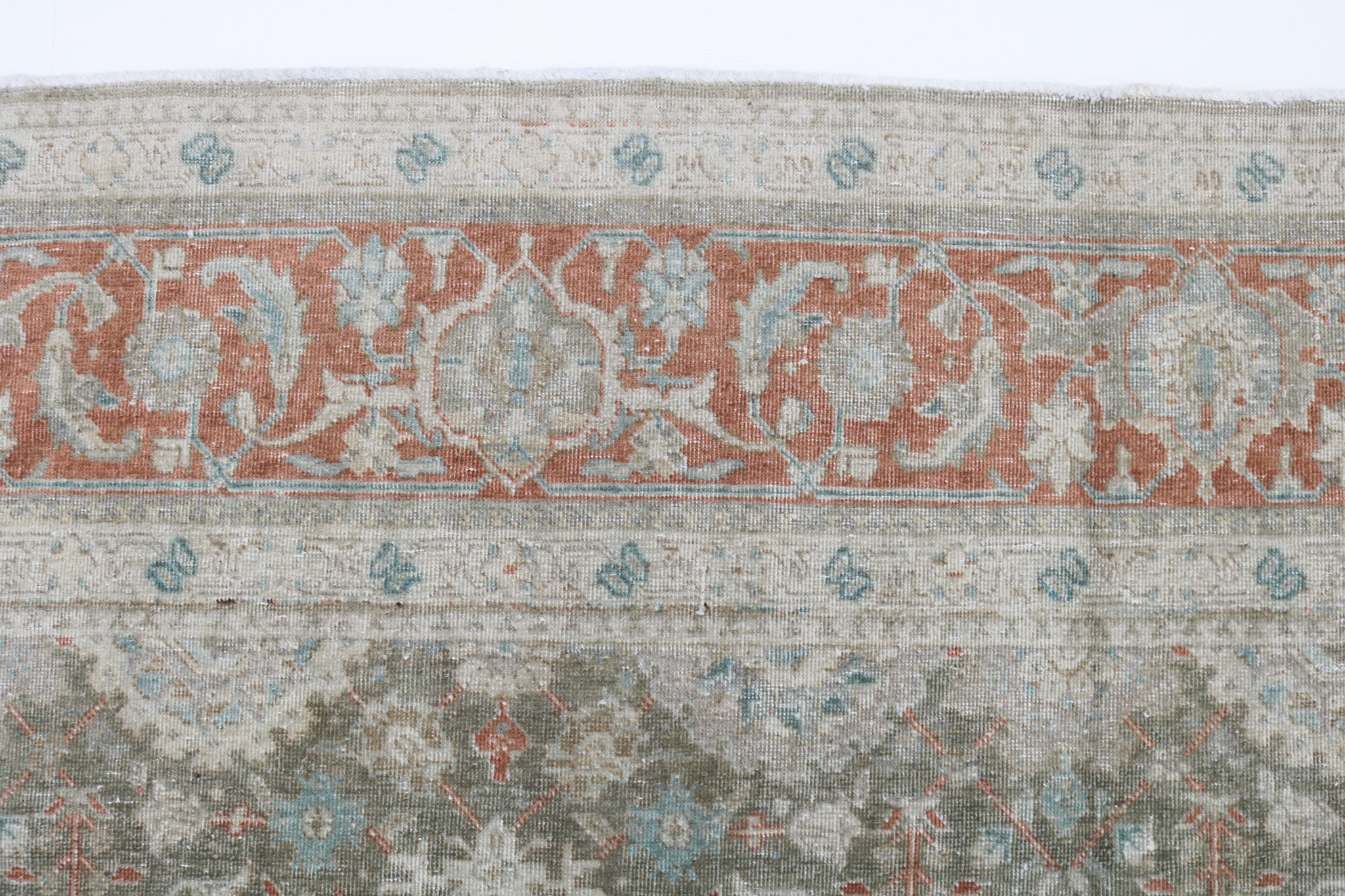 Close-up detail of antique Persian Heriz rug showing handwoven geometric motifs and natural wool colours