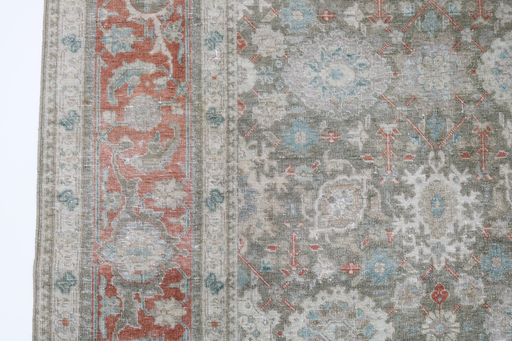Close-up detail of antique Persian Heriz rug showing handwoven geometric motifs and natural wool colours