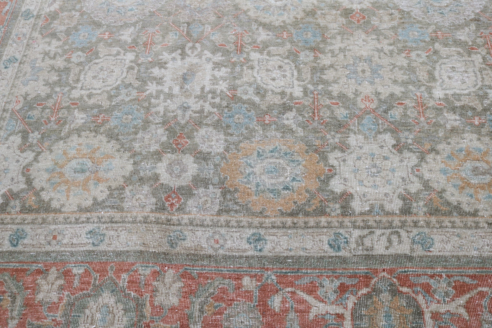 Close-up detail of antique Persian Heriz rug showing handwoven geometric motifs and natural wool colours