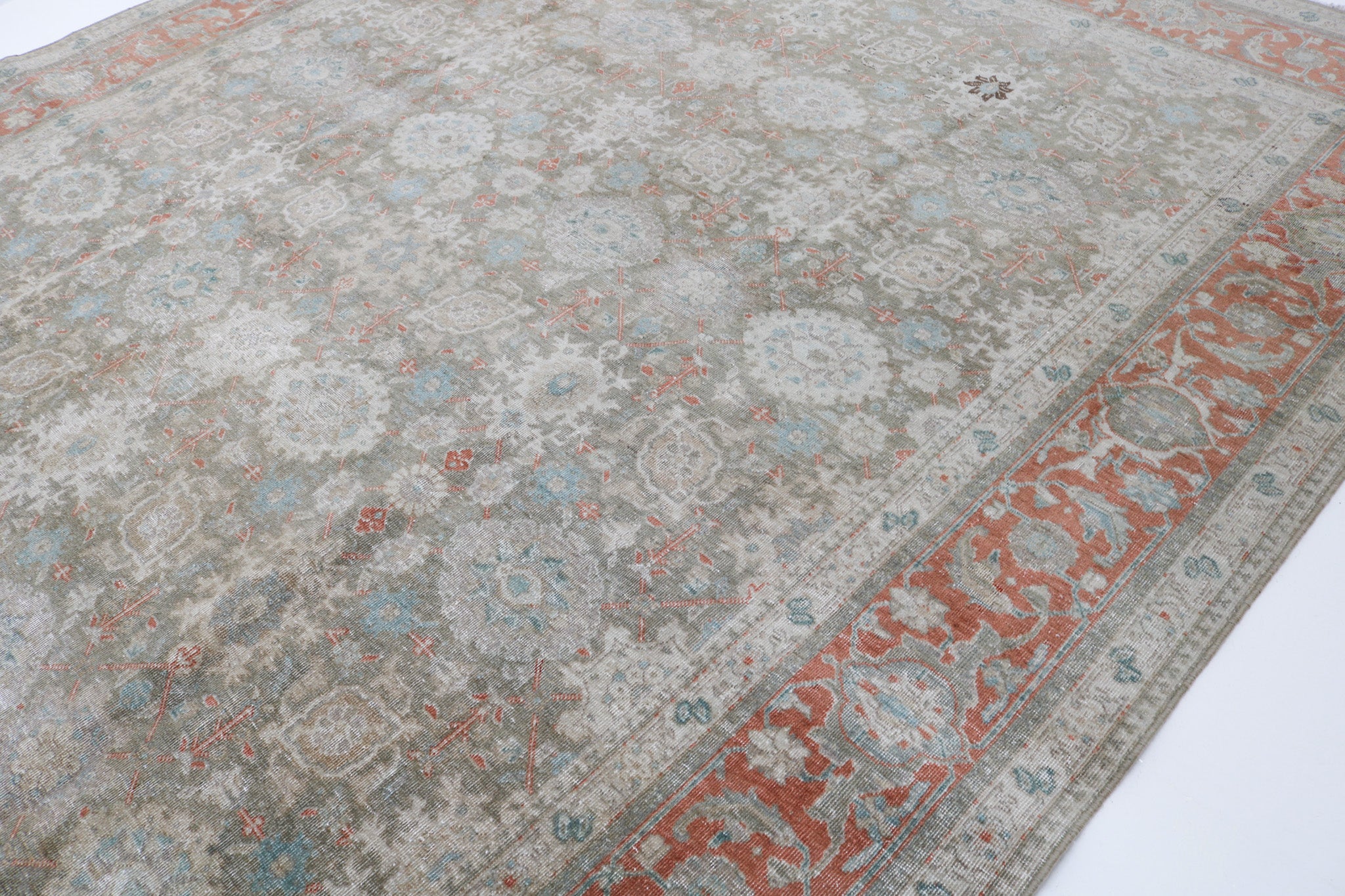 Close-up detail of antique Persian Heriz rug showing handwoven geometric motifs and natural wool colours