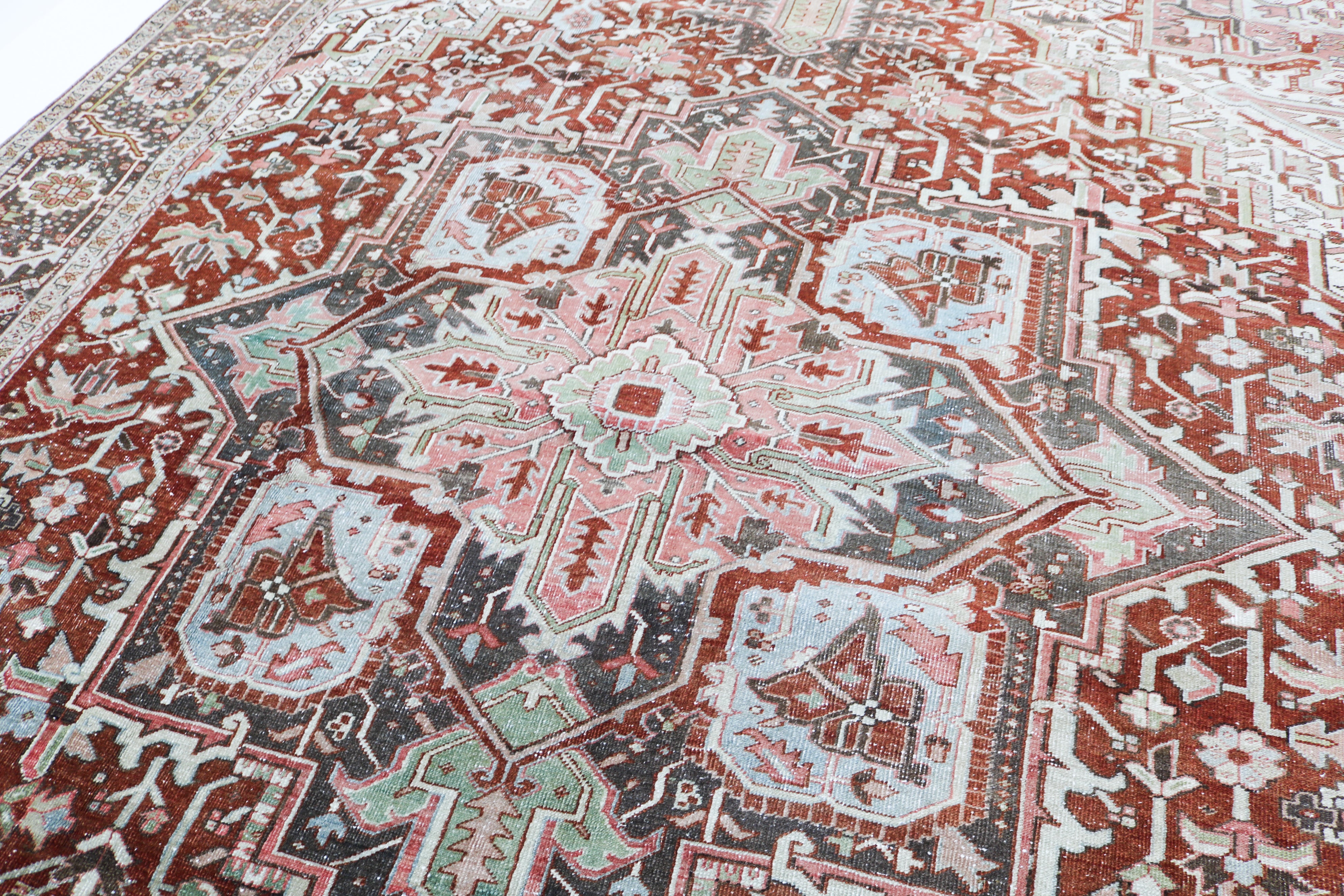 Close-up detail of antique Persian Heriz rug showing handwoven geometric motifs and natural wool colours