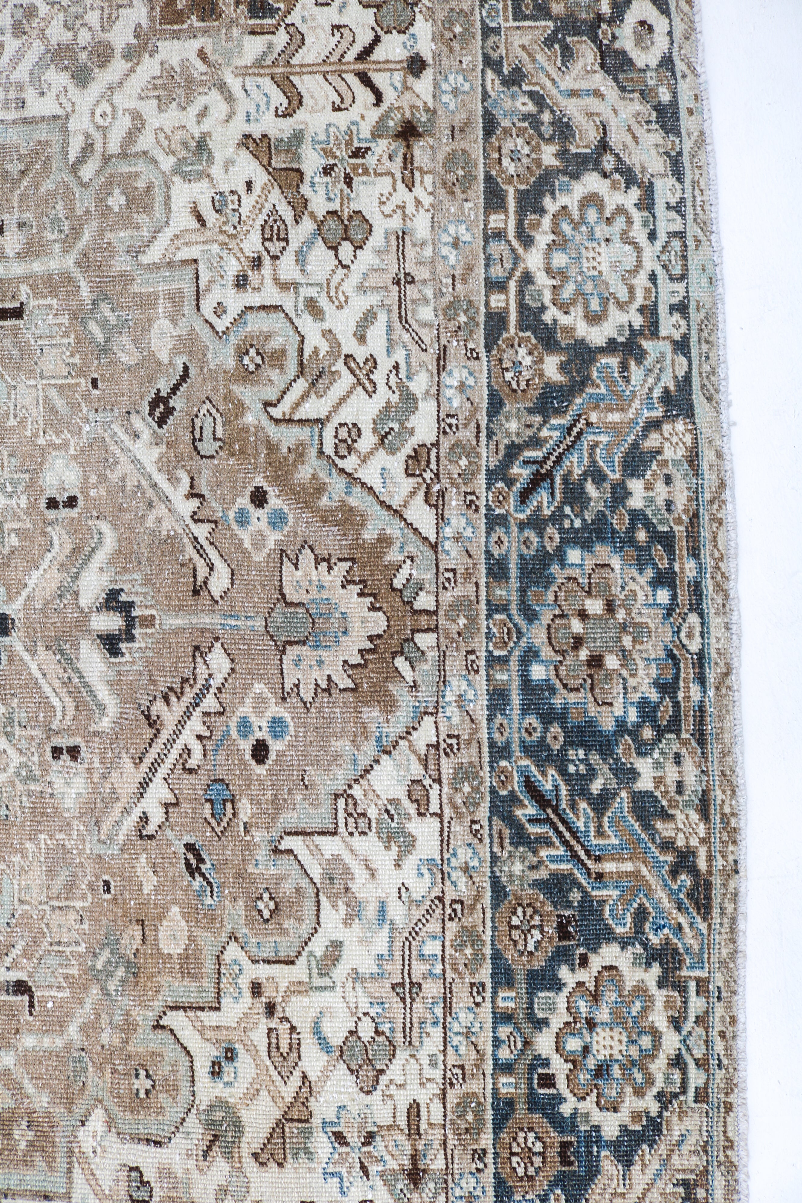 Handwoven Persian Heriz rug detail with authentic aged character and architectural motifs