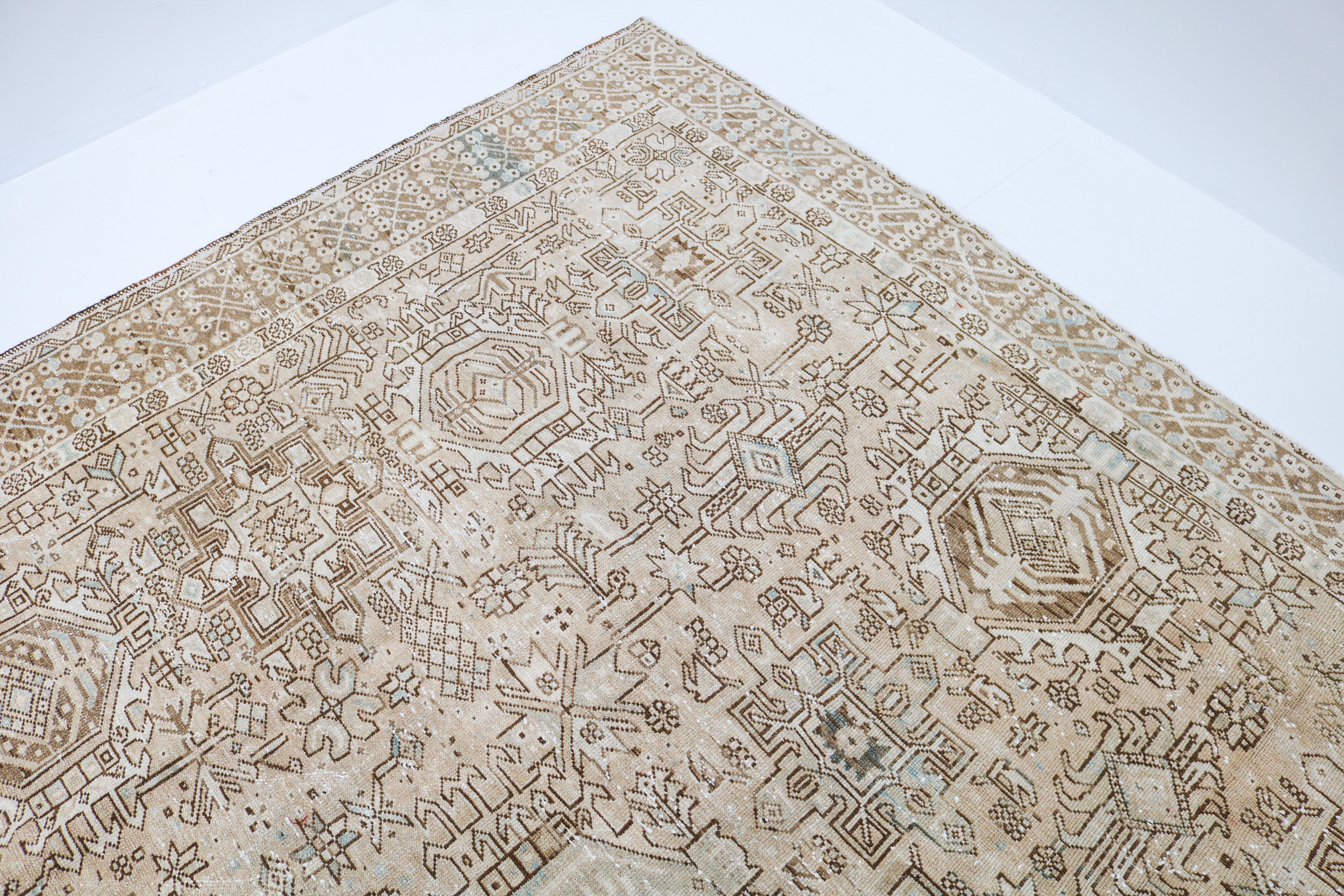 Close-up detail of antique Persian Heriz-Karaja rug showing handwoven tribal motifs and aged wool colours