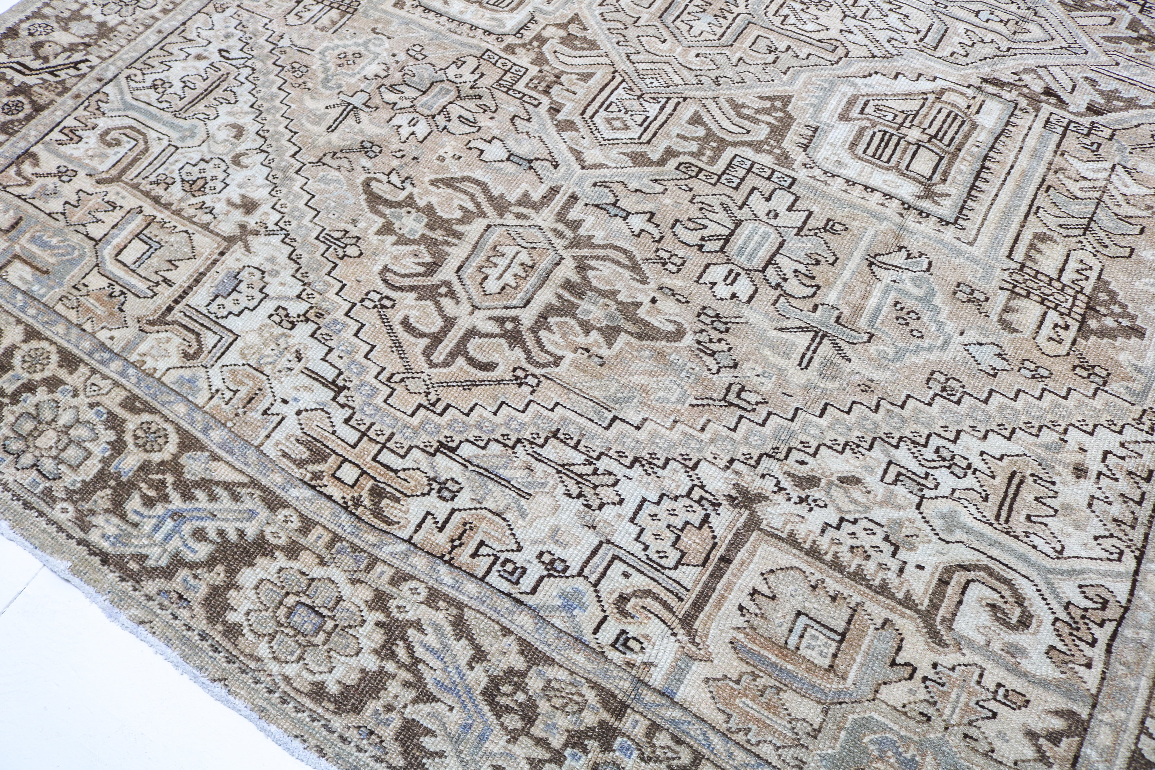 Antique Persian carpet close-up showing fine geometric weaving and subtle natural colour variation