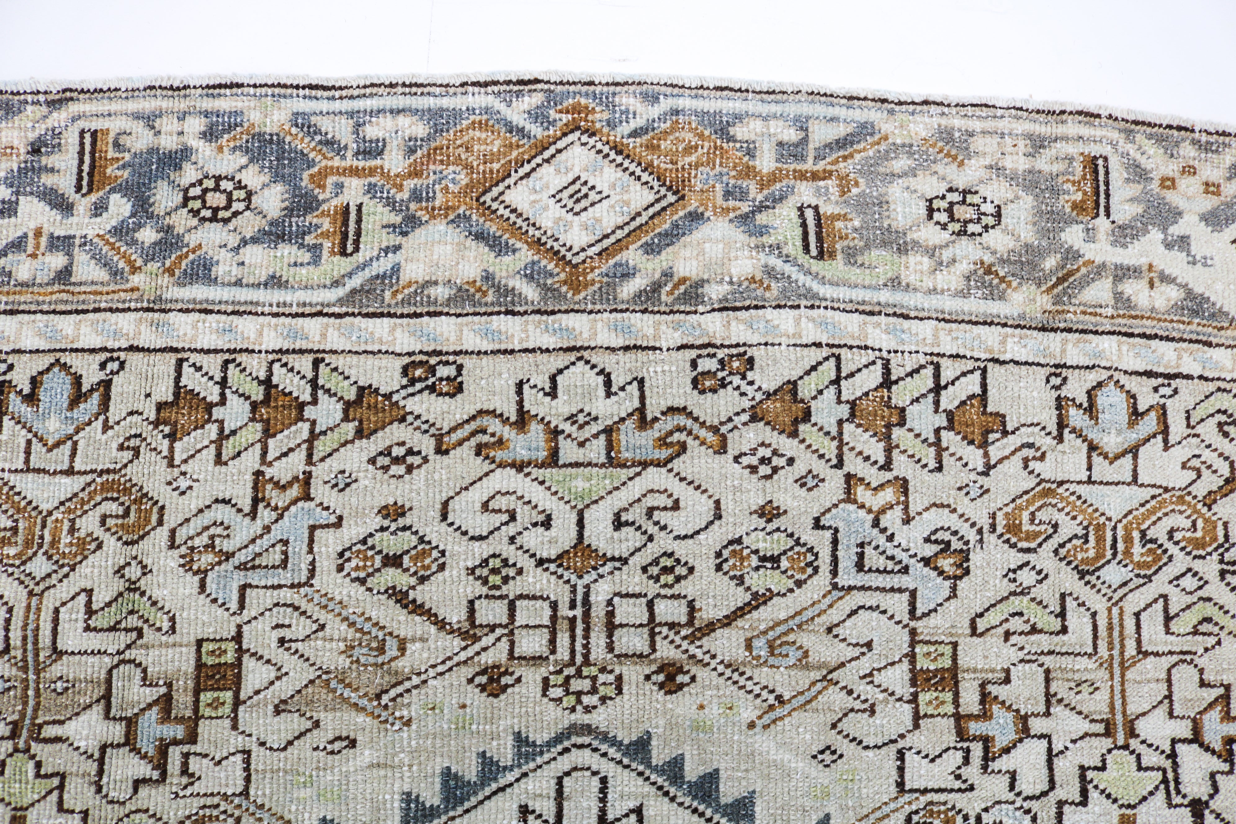 Antique Persian carpet close-up showing fine geometric weaving and subtle natural colour variation