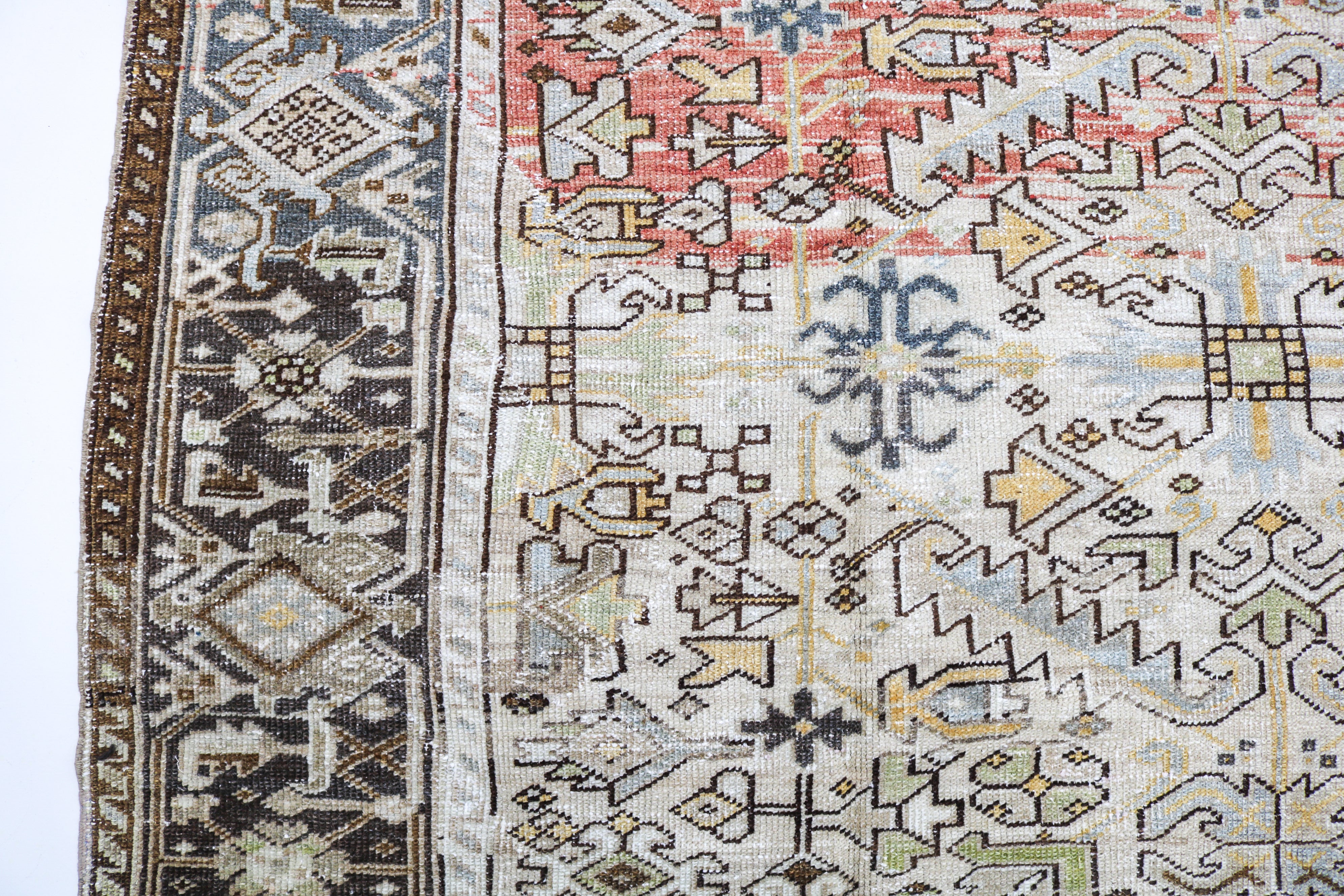Antique Persian carpet close-up showing fine geometric weaving and subtle natural colour variation