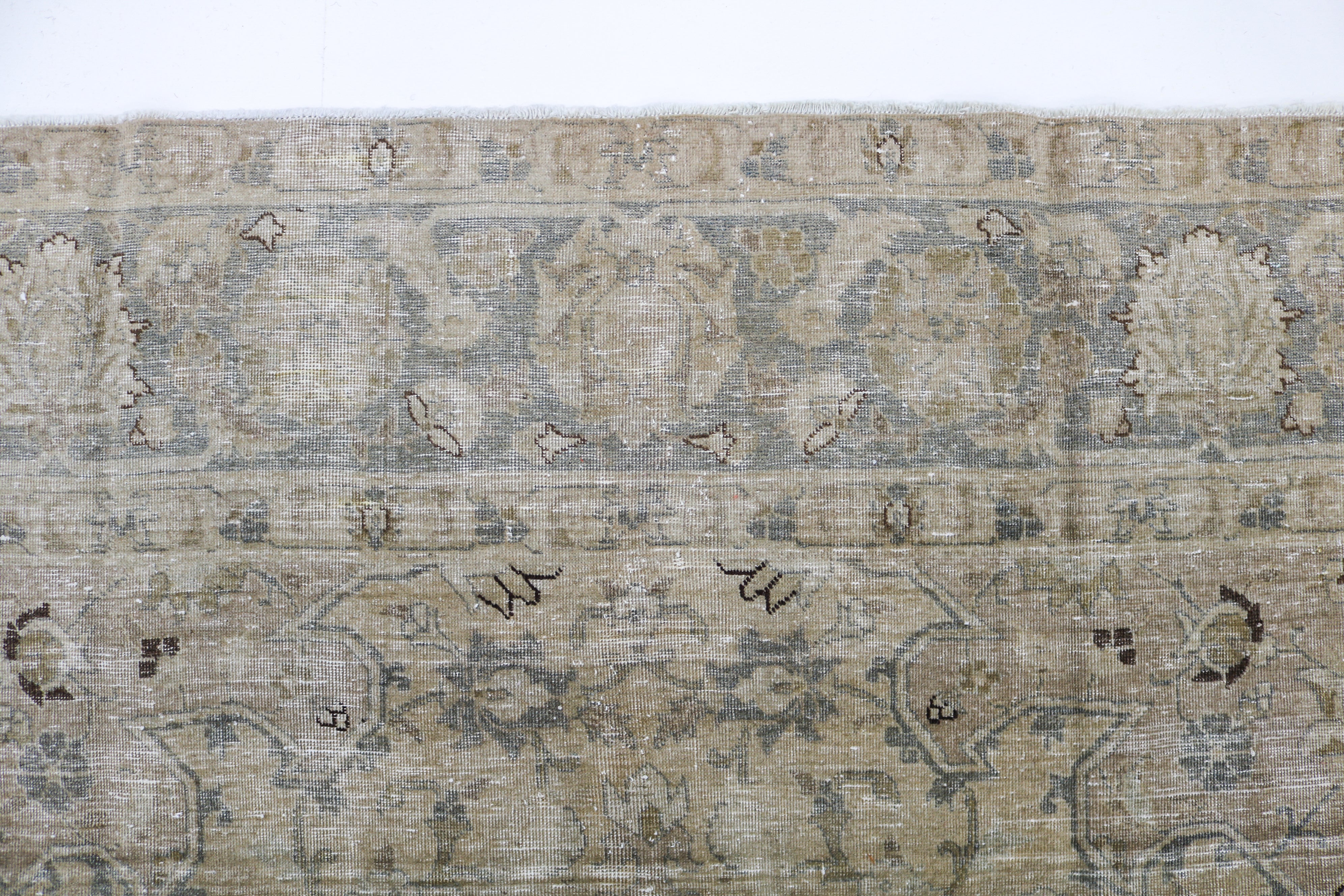 Antique Tabriz carpet detail featuring elegant floral design and subtle ivory accents