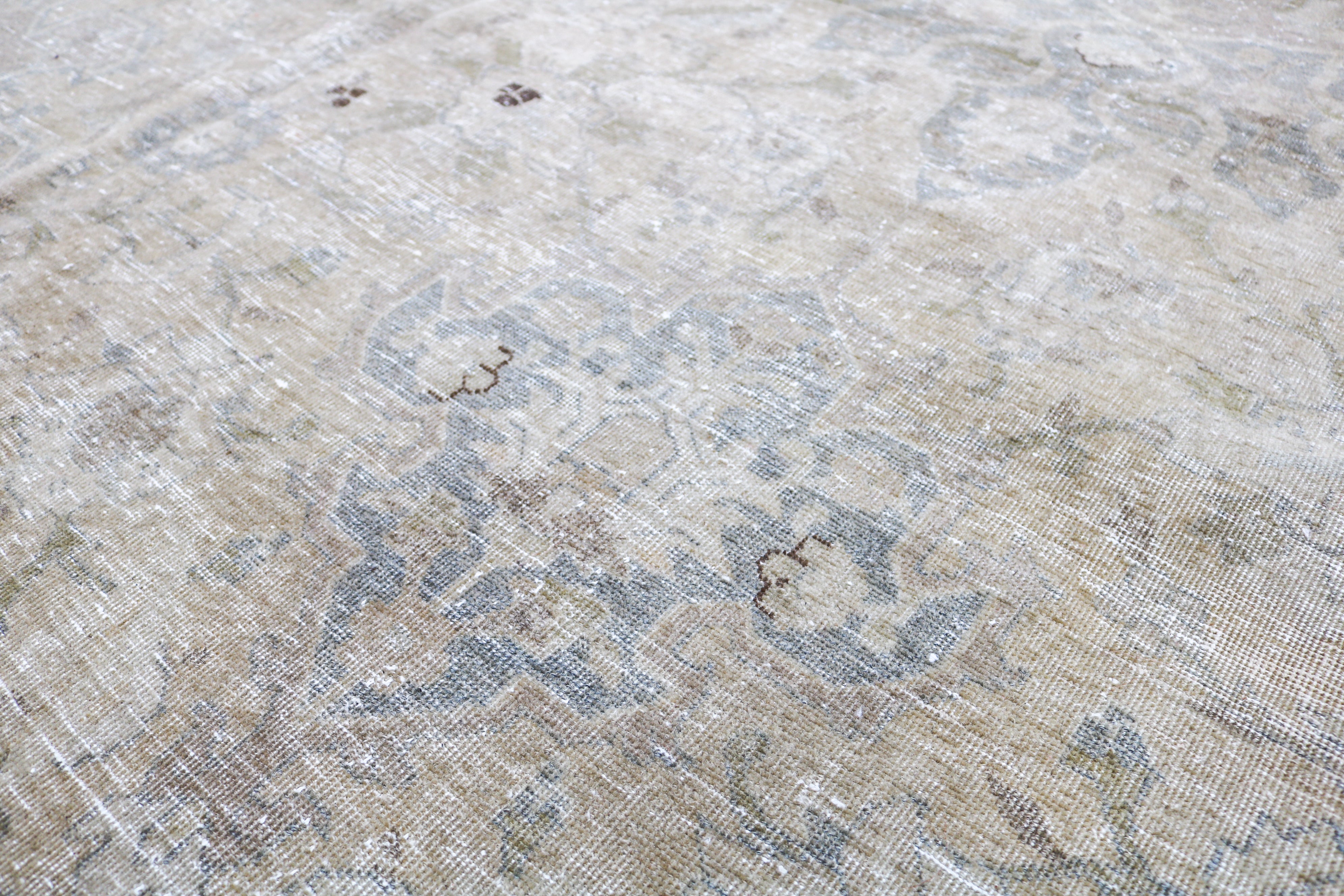Antique Tabriz carpet detail featuring elegant floral design and subtle ivory accents