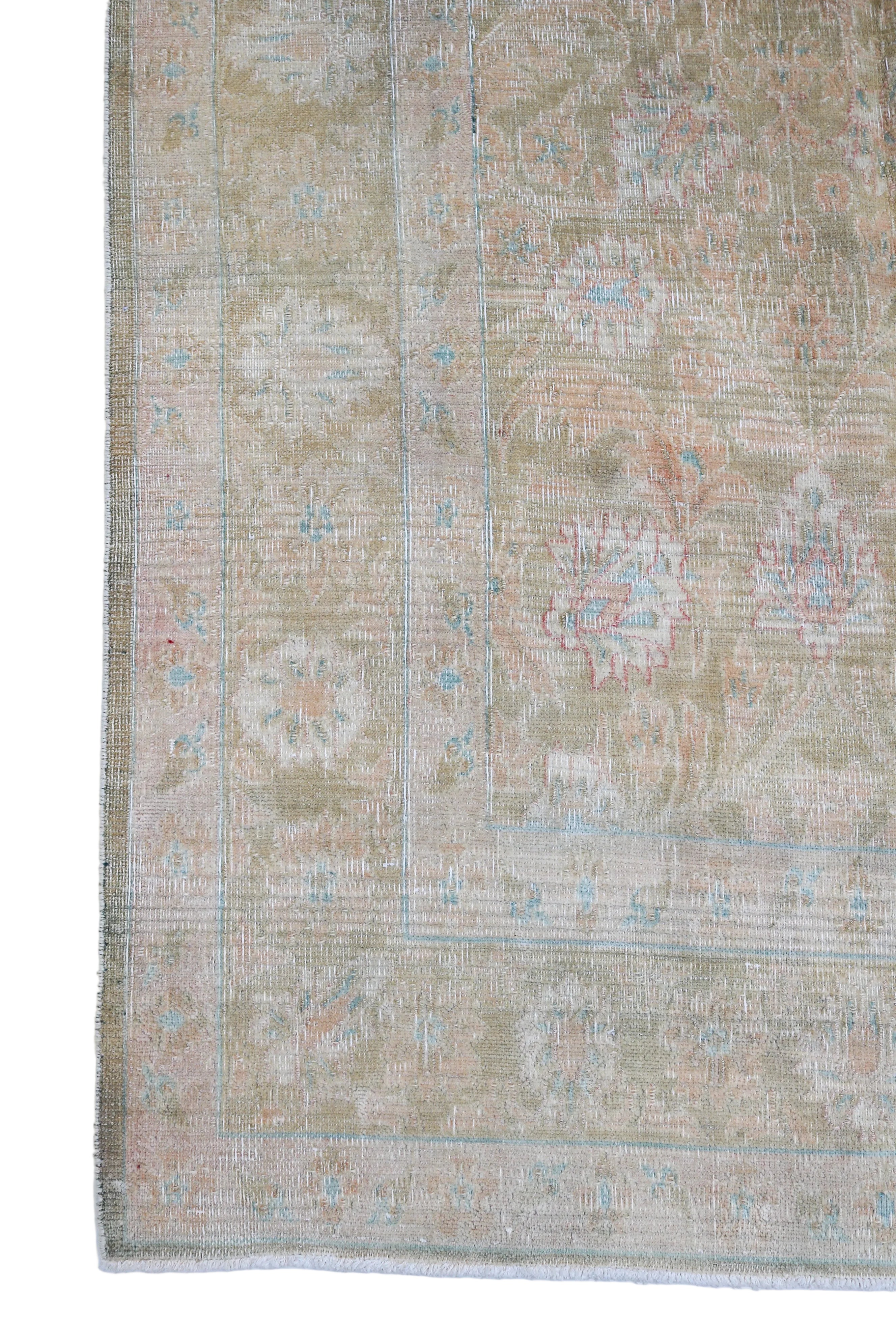 Vintage Persian Sarouk carpet corner detail with floral border and softly aged pastel tones circa 1940