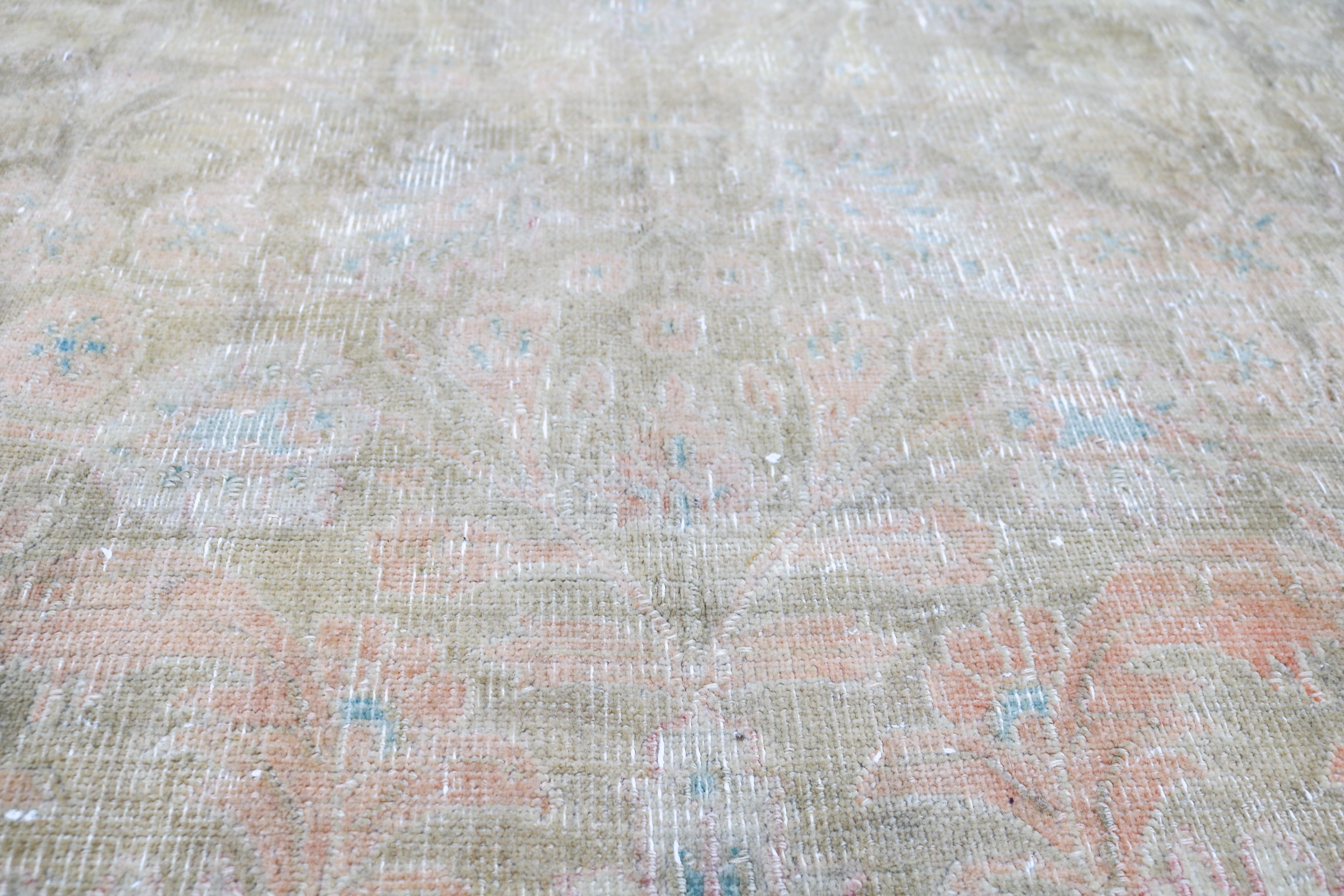 Vintage Sarouk carpet detail featuring refined floral design and subtle blush accents