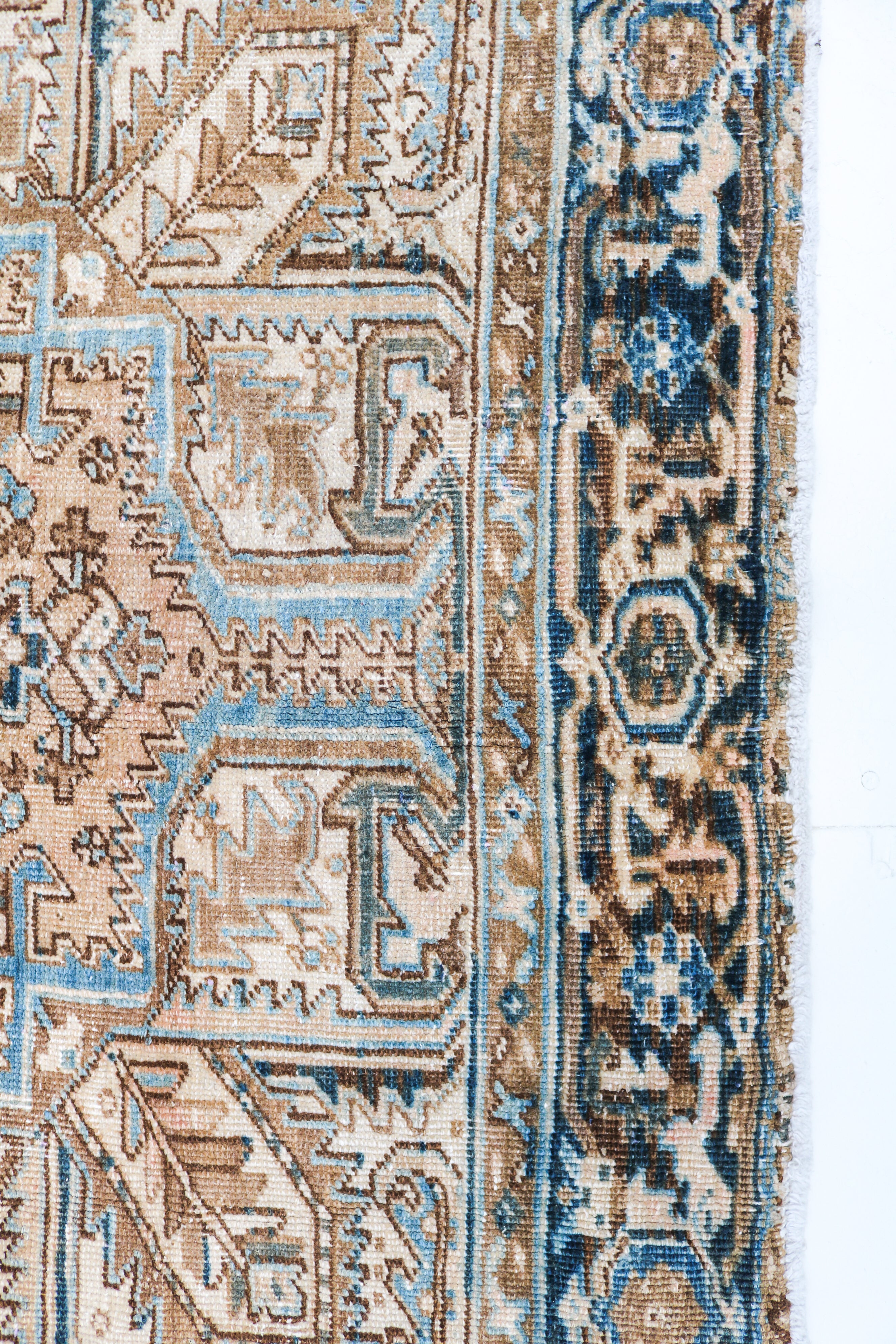 Antique Heriz rug detail featuring traditional geometric medallion and ivory accents