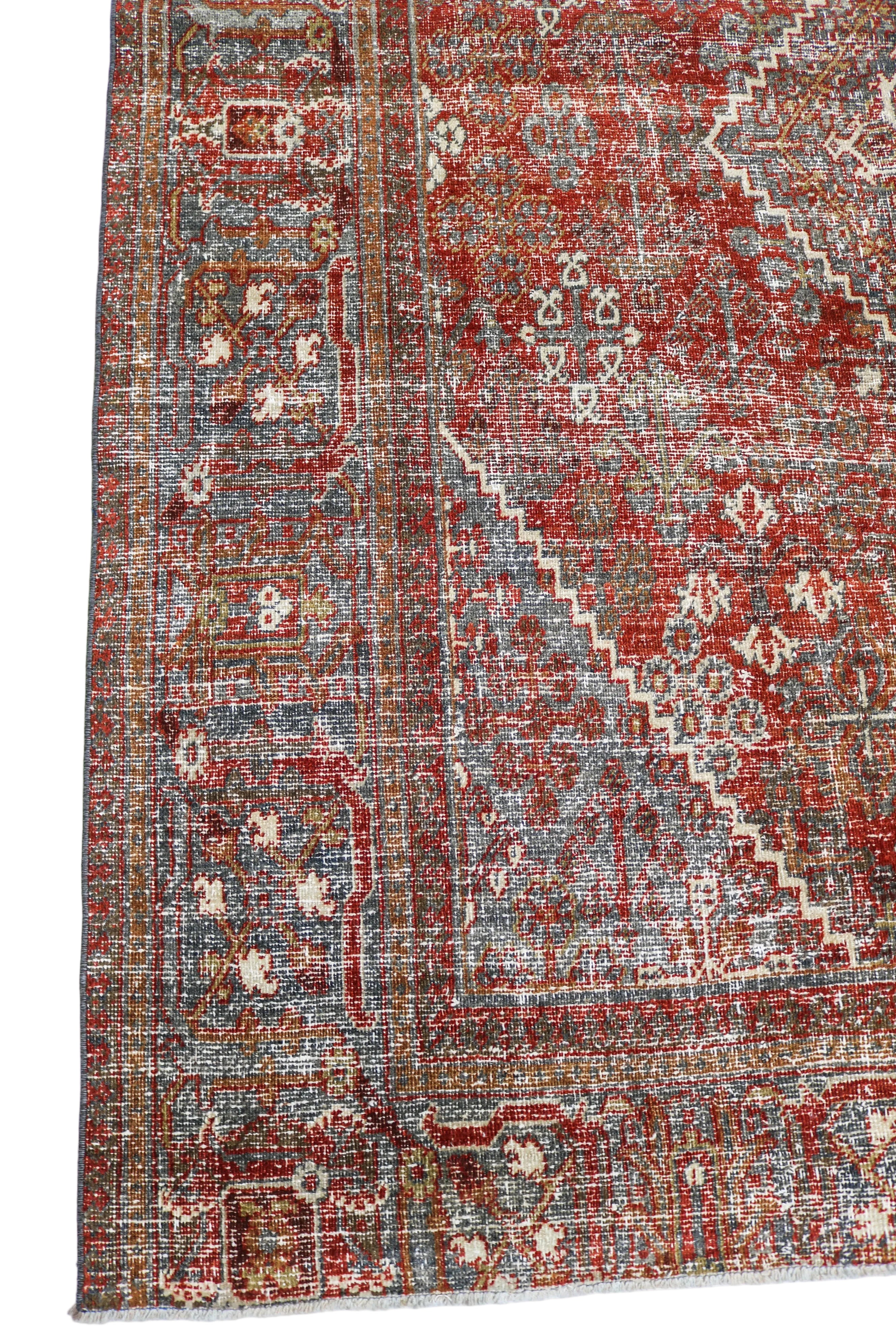 Antique Persian Josheqan carpet corner detail with geometric border and rich terracotta tones circa 1930