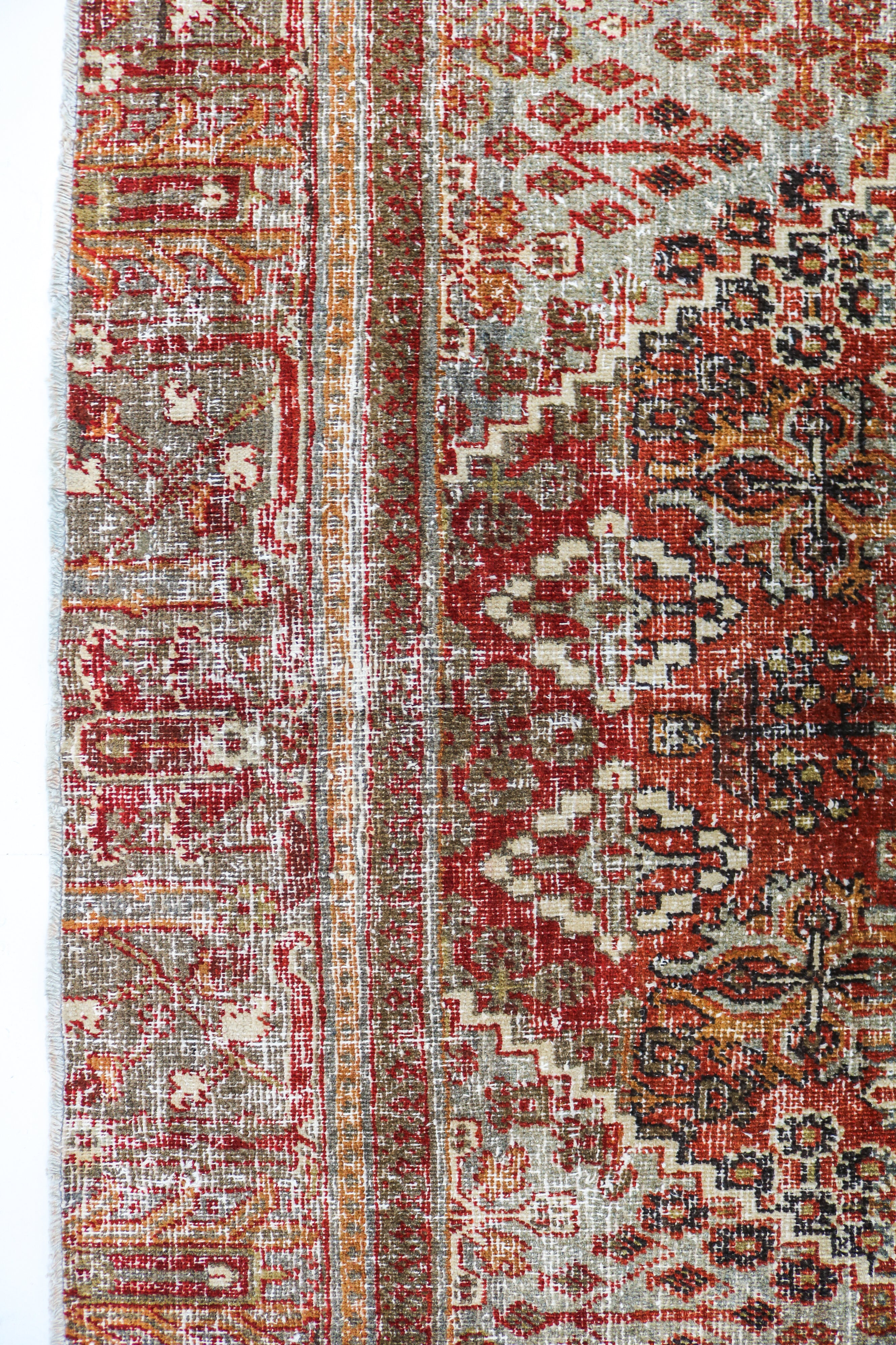 Close-up detail of antique Persian Josheqan rug showing handwoven floral motifs and aged wool colours