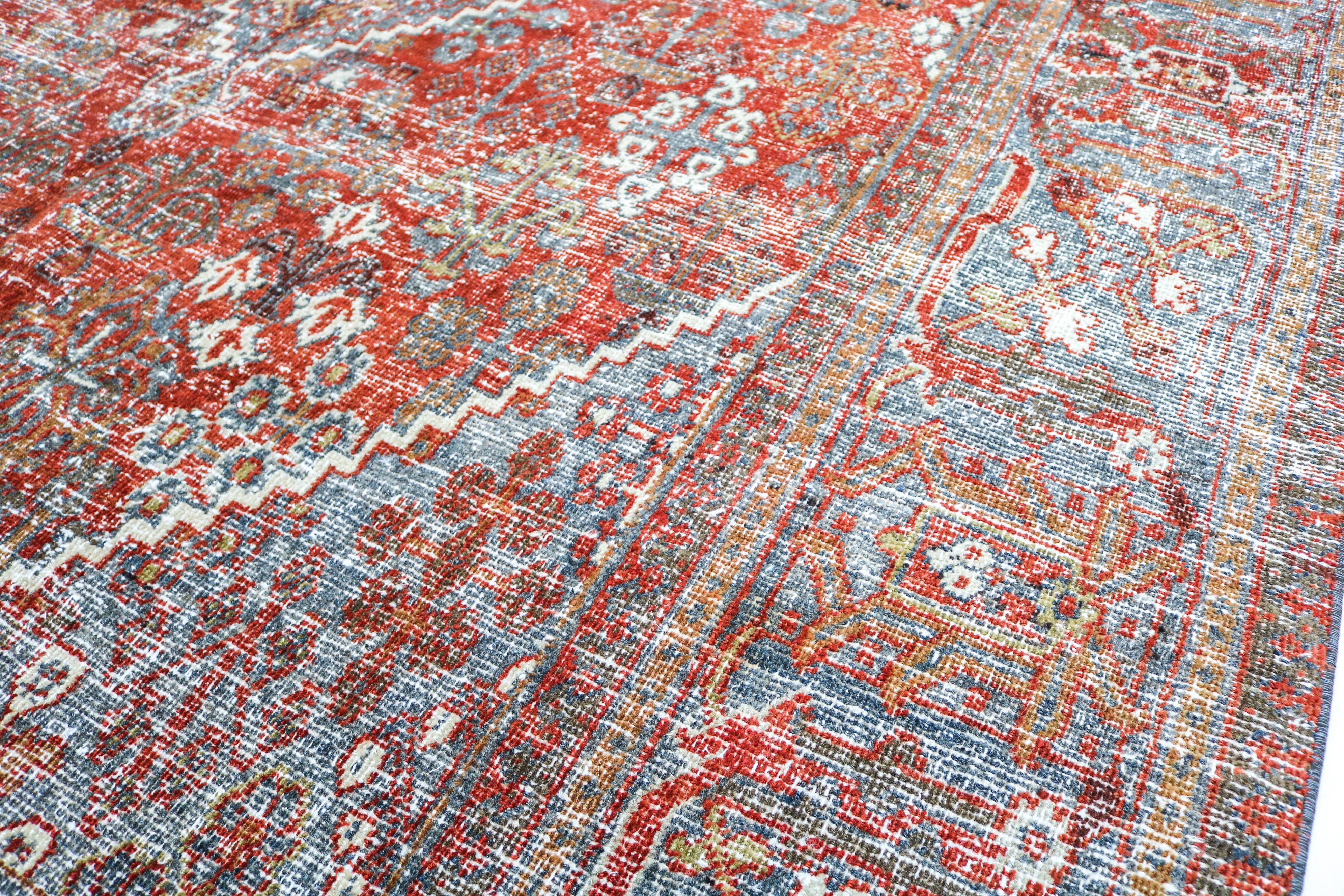 Close-up detail of antique Persian Josheqan rug showing handwoven floral motifs and aged wool colours