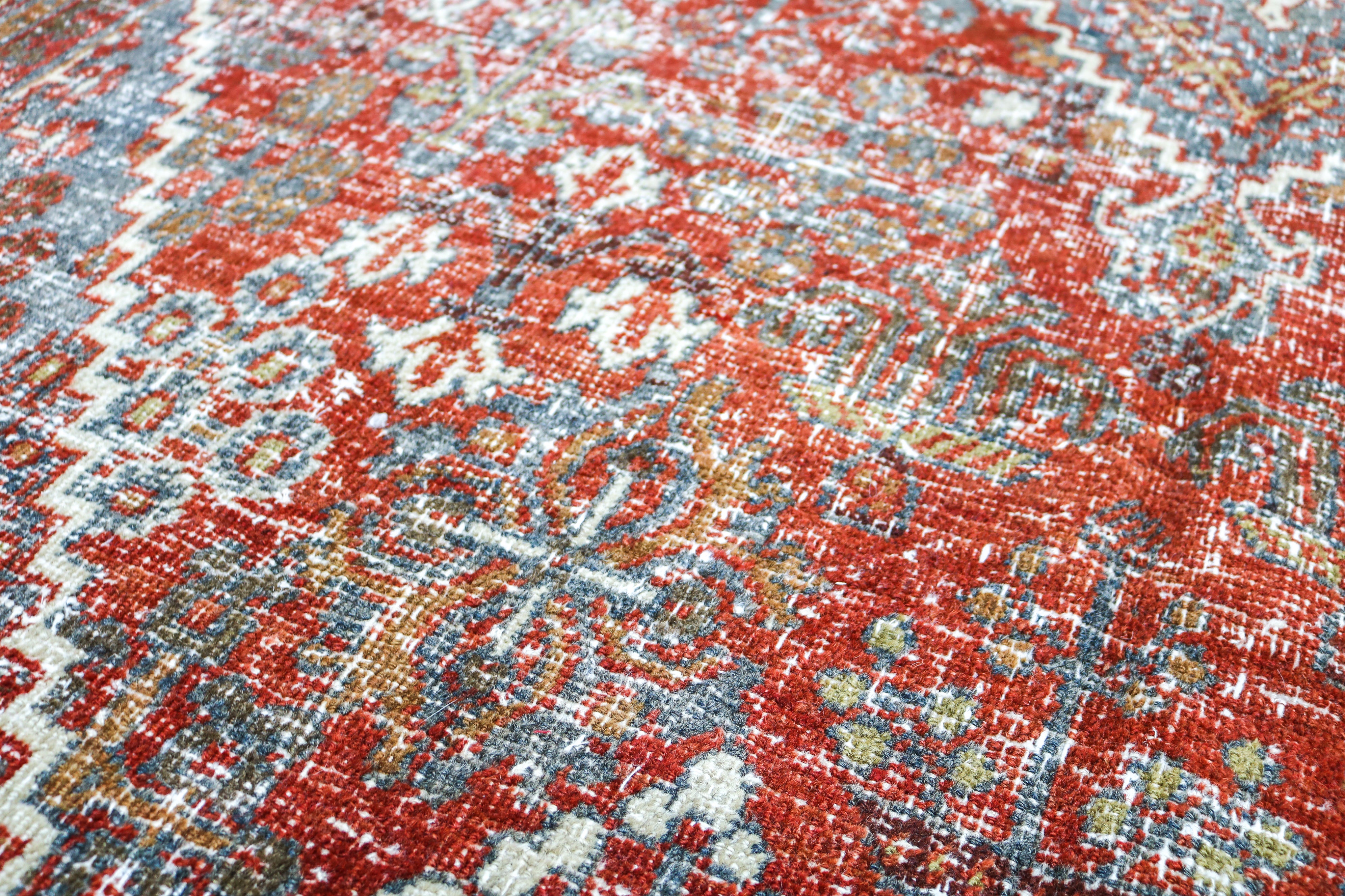 Antique Josheqan carpet detail featuring traditional geometric medallion and faded blue accents