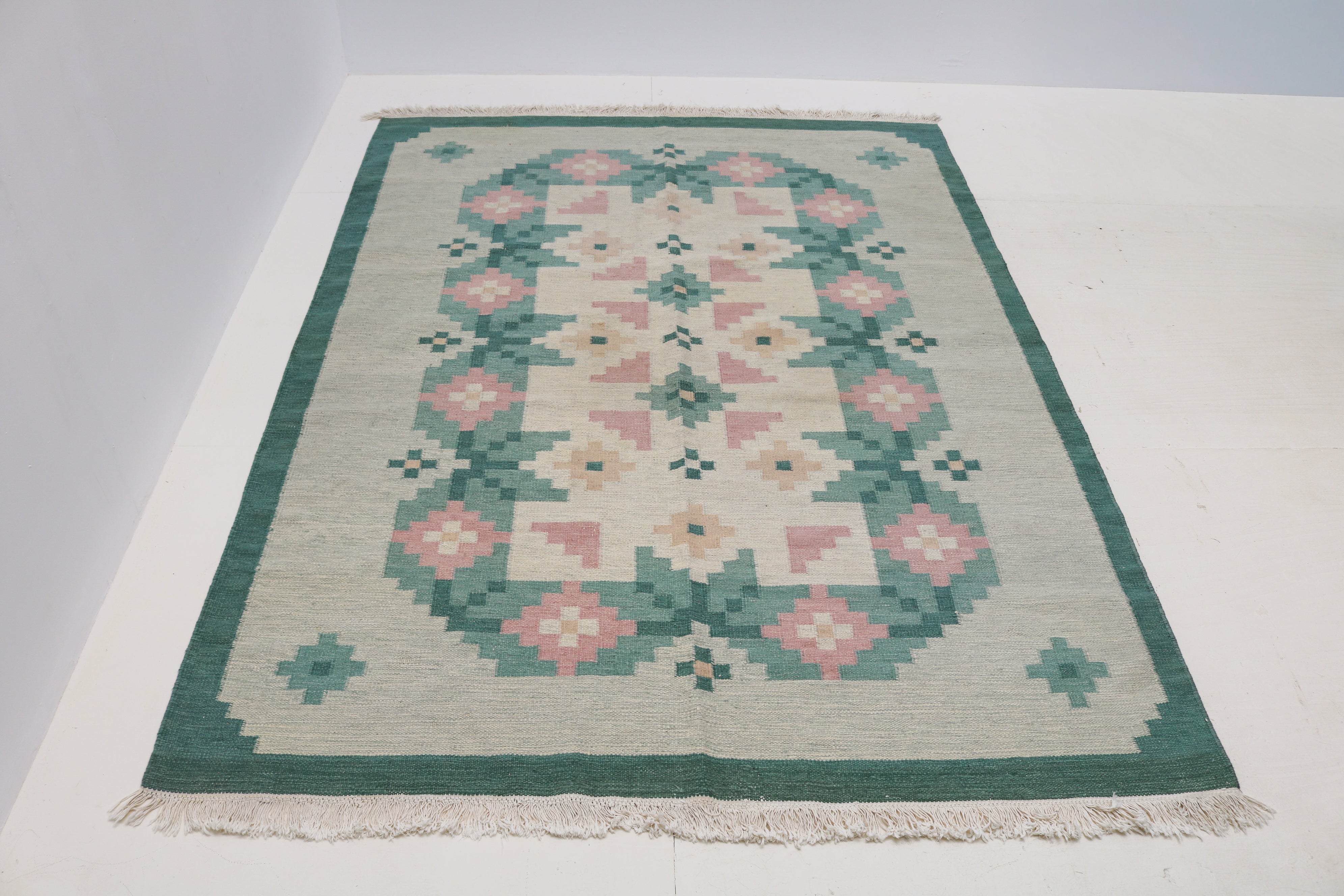 Vintage Swedish flatweave rug with soft green and dusty pink geometric floral motifs