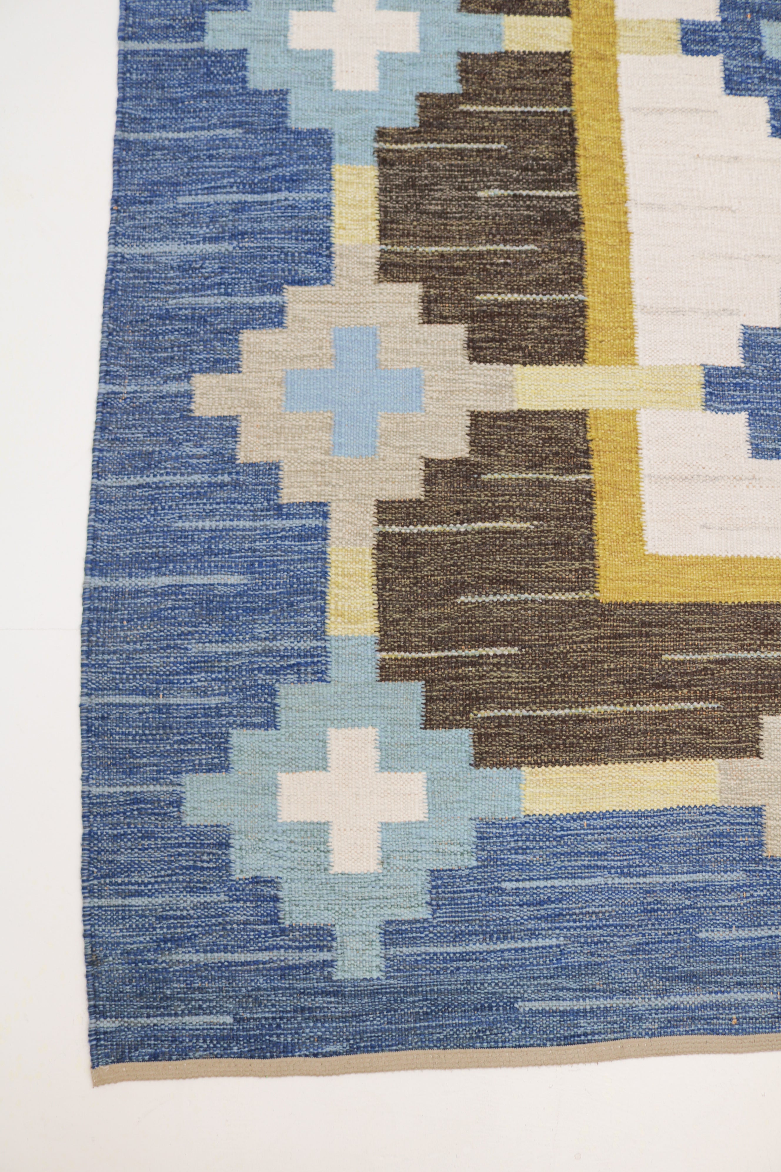 Close-up of vintage Swedish kilim rug with blue, brown and ivory geometric design