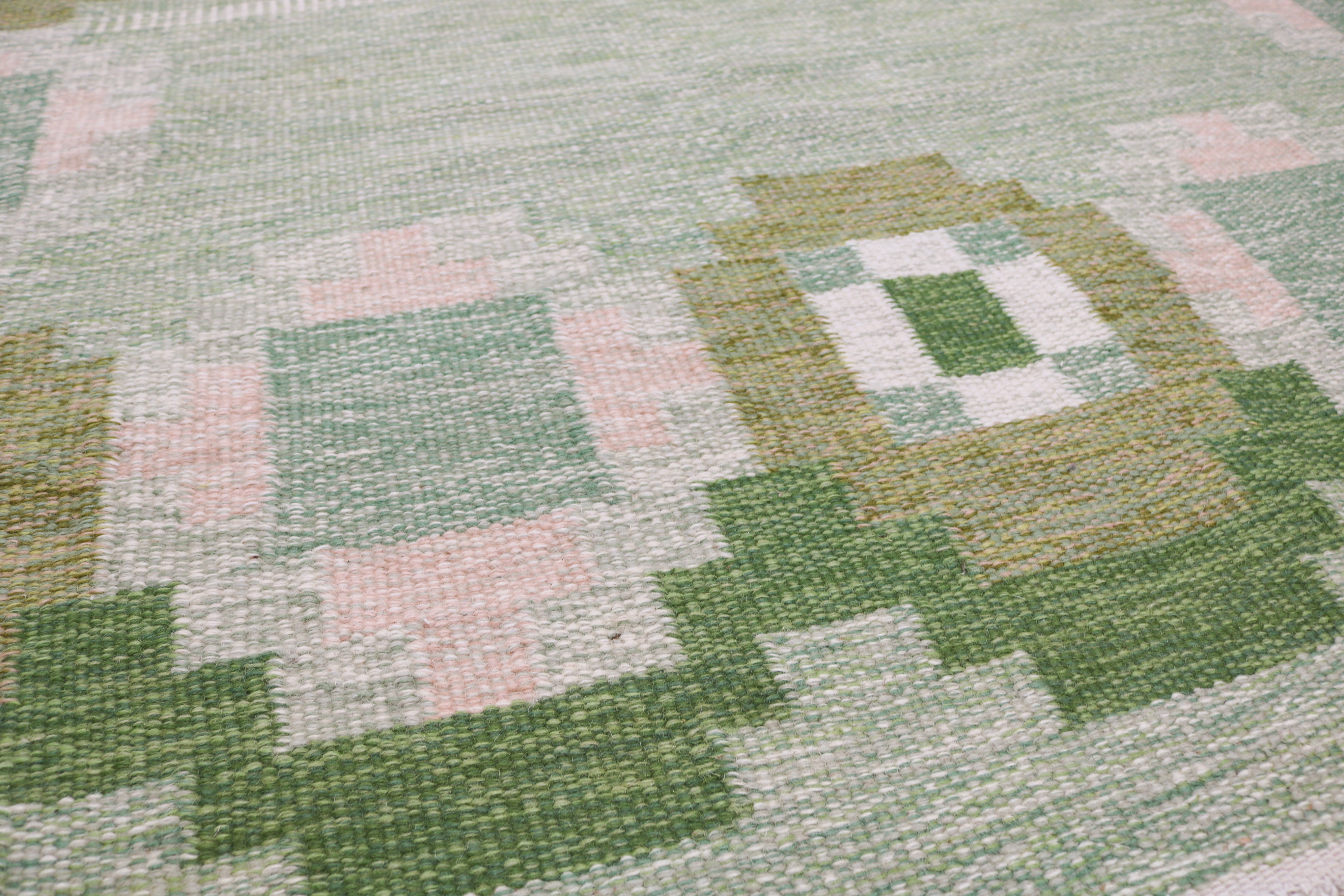 Detail of vintage Swedish kilim with green, olive, ivory and pale pink motifs