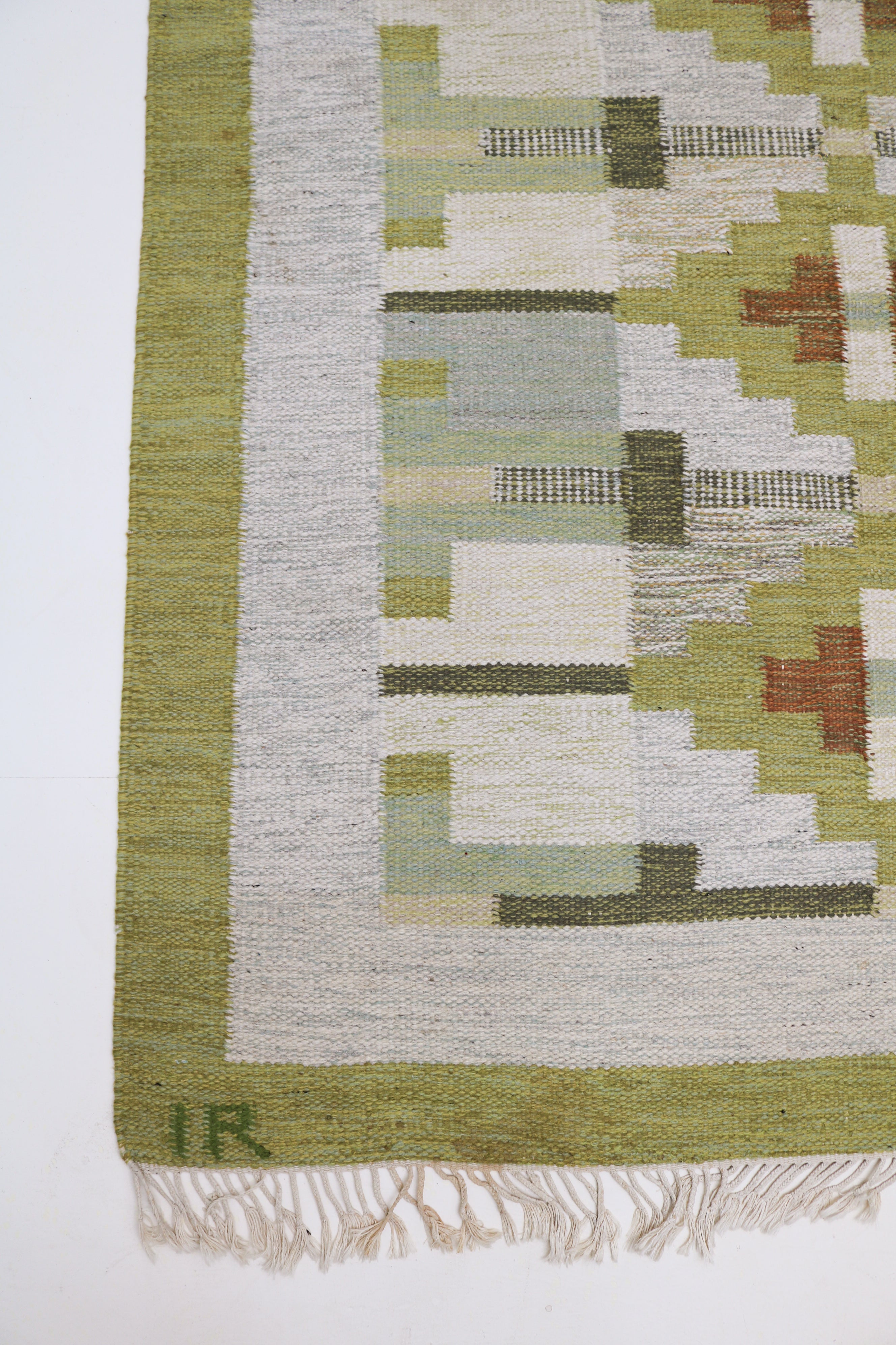 Close-up of vintage Swedish kilim rug with olive green geometric design