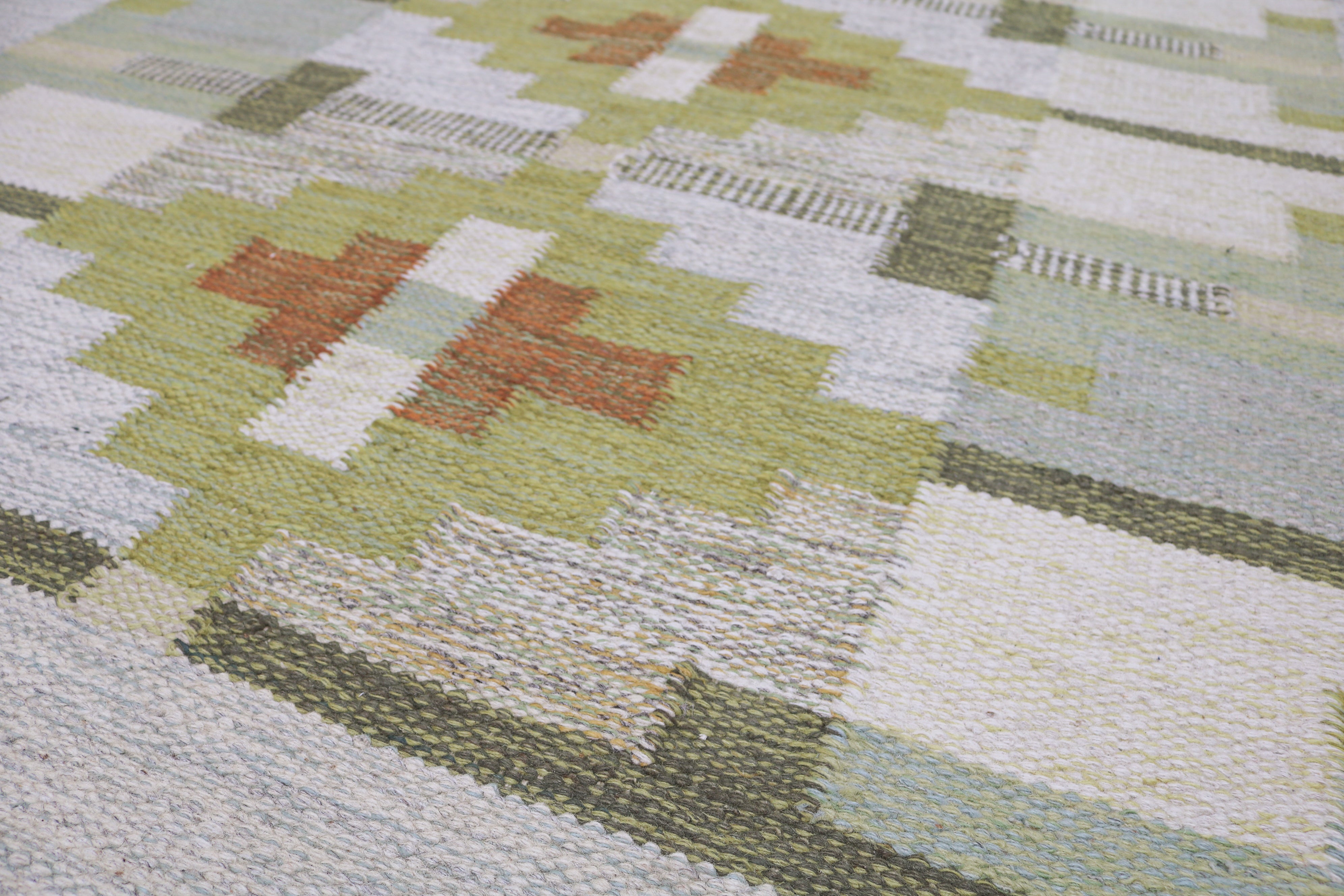 Detail of vintage Swedish kilim with olive green, ivory and rust motifs