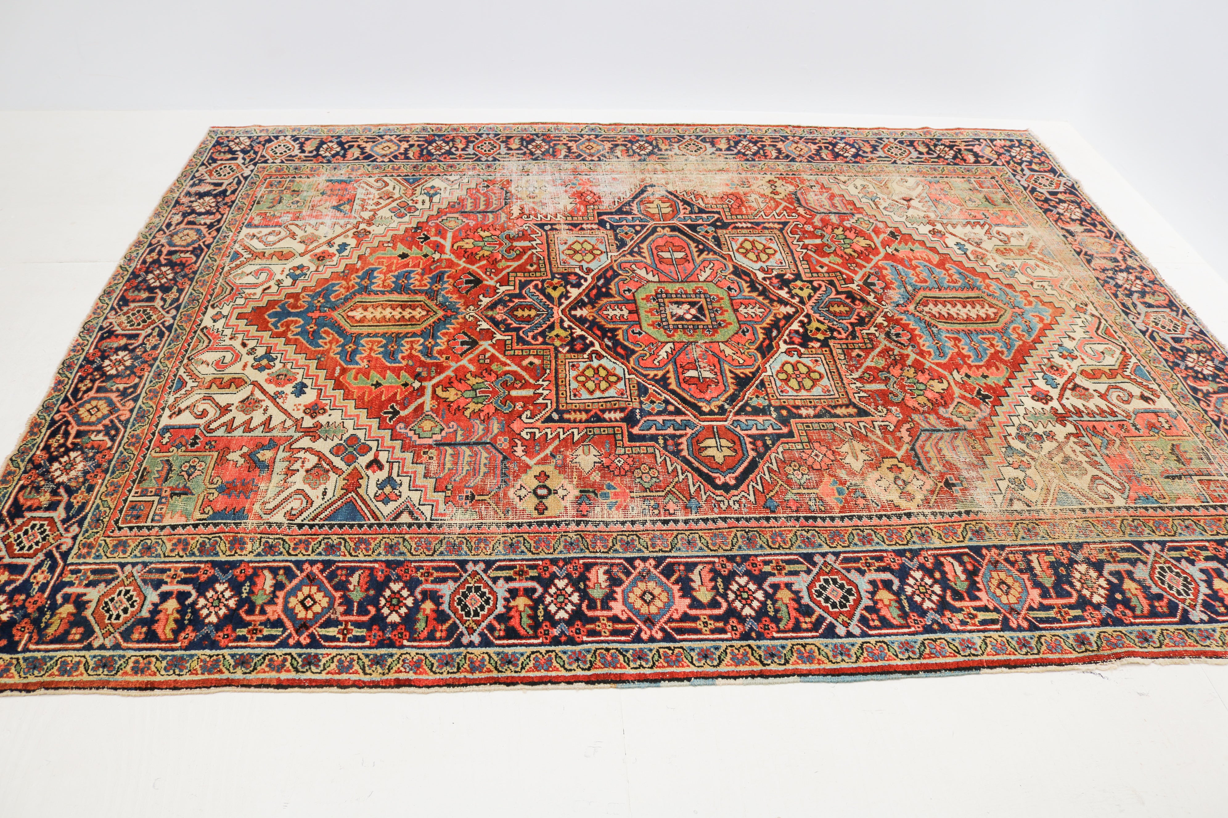 Hand-knotted wool detail of antique Persian Heriz rug with traditional geometric design