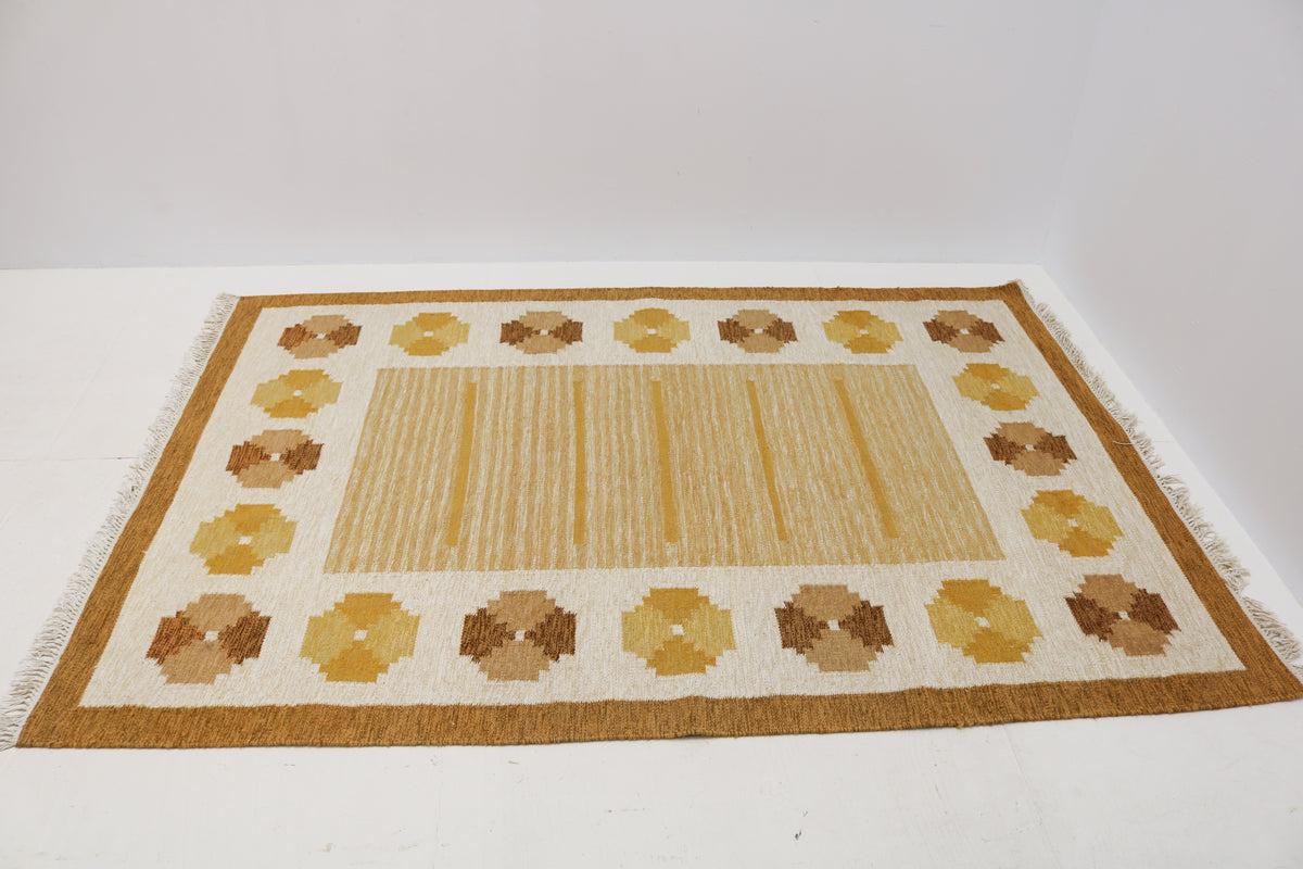 Angled view of Swedish Kilim rug featuring warm ochre, mustard and caramel geometric motifs