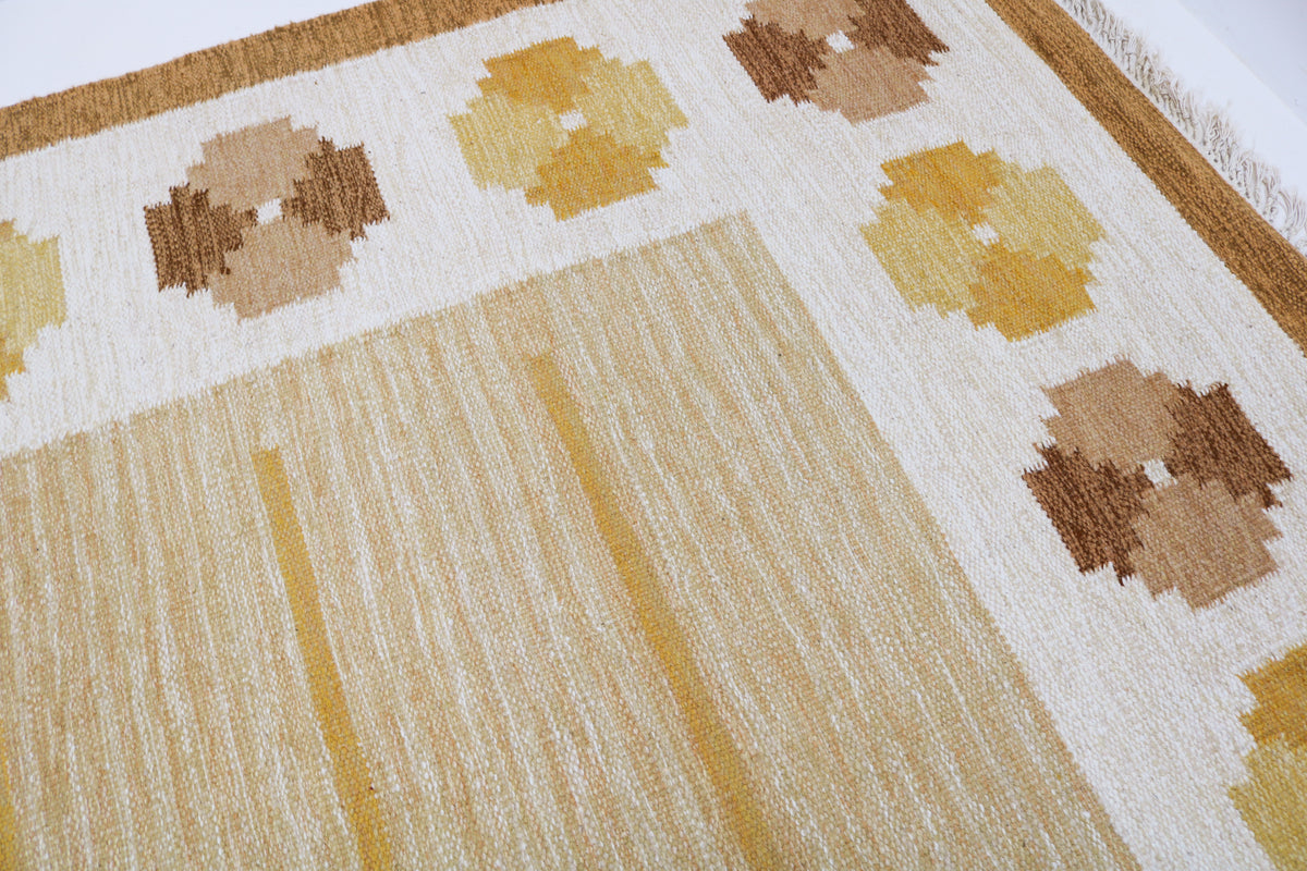 Close-up of vintage Swedish Kilim rug featuring ochre geometric motifs and natural woven texture