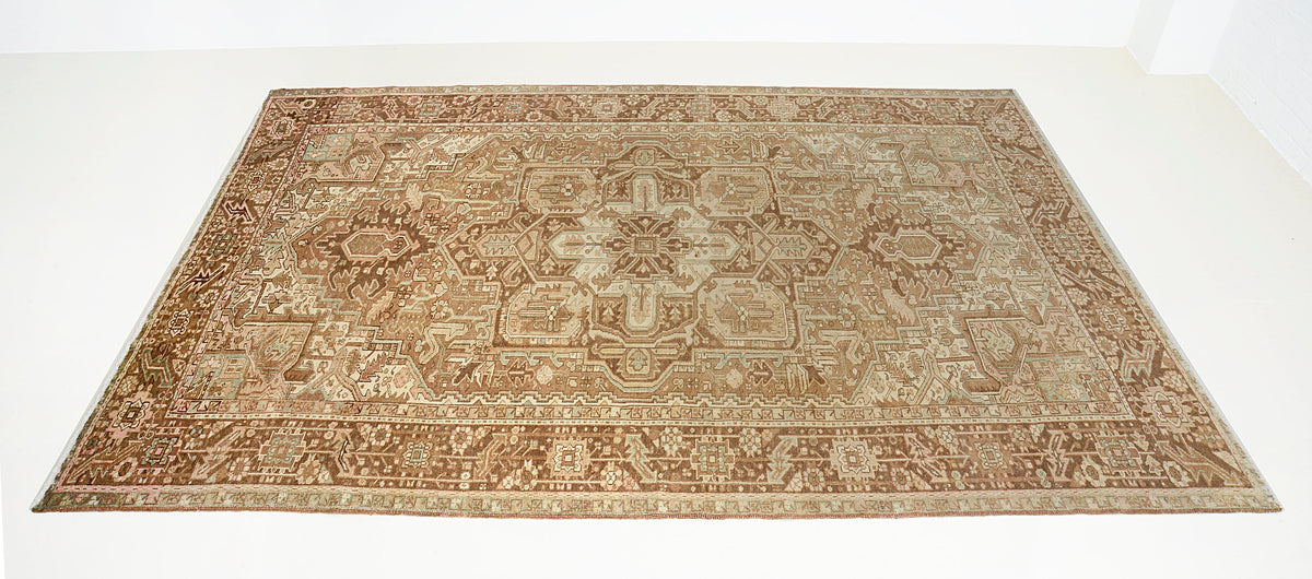Full Persian Heriz carpet showing balanced geometric composition in brown and muted neutral tones