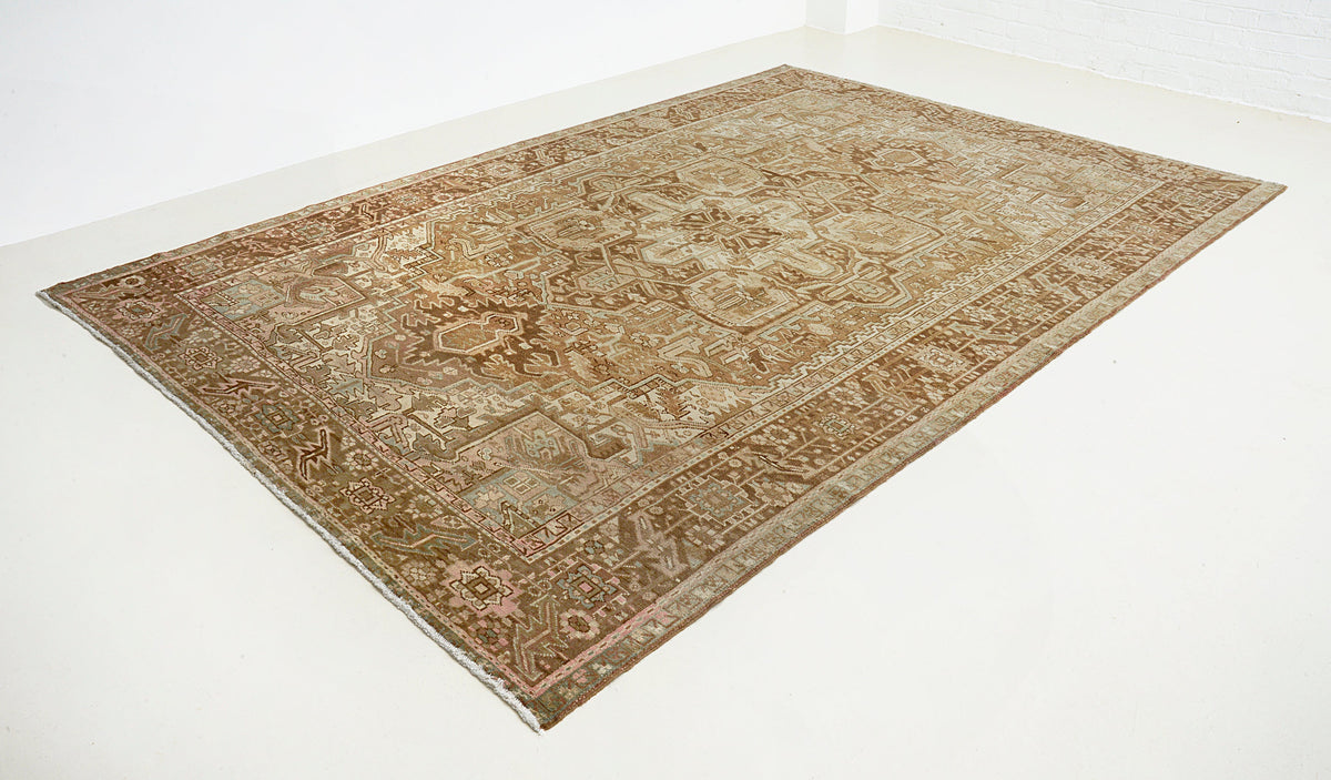 Angled view of vintage Heriz carpet featuring warm brown, beige and subtle earthy colours